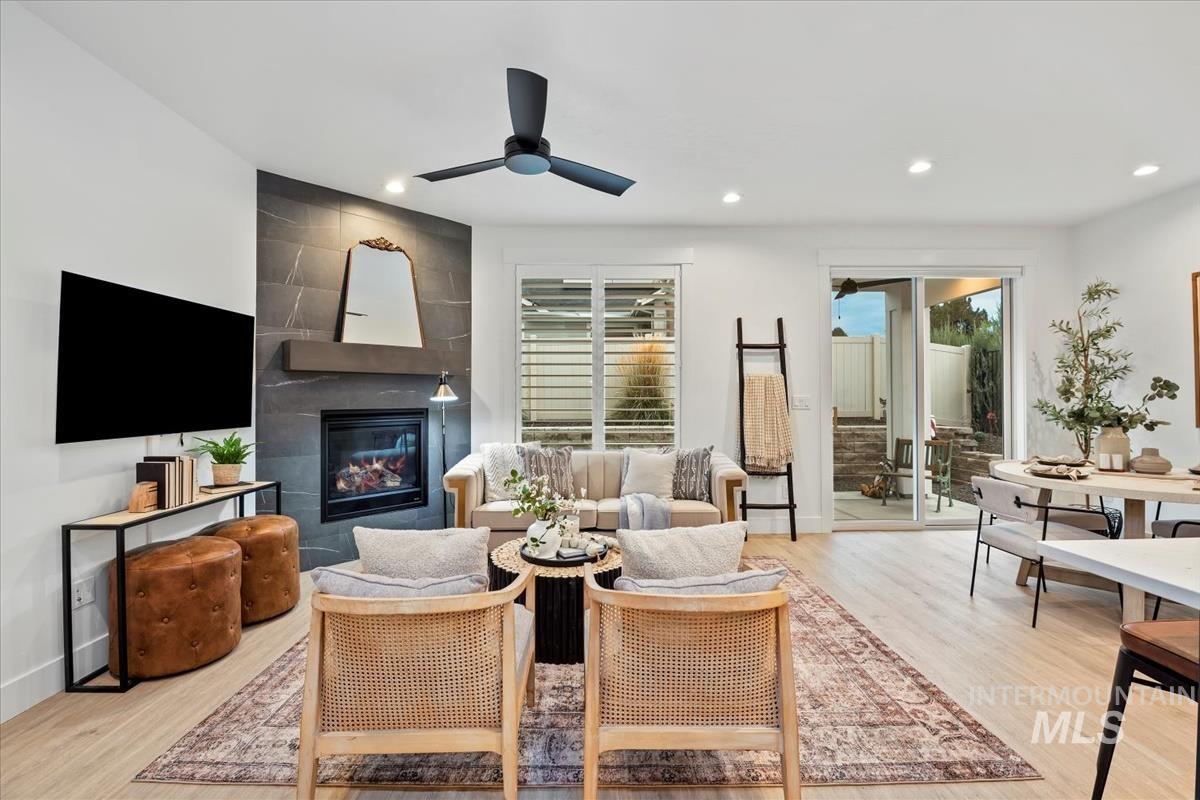 Living room featuring light wood finished floors, recessed lighting, a large fireplace, and plenty of natural light