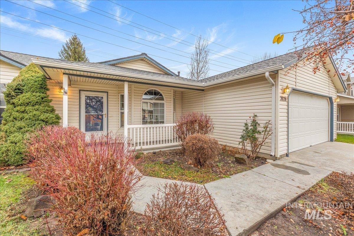 Single story home with roof with shingles, a porch, and an attached garage