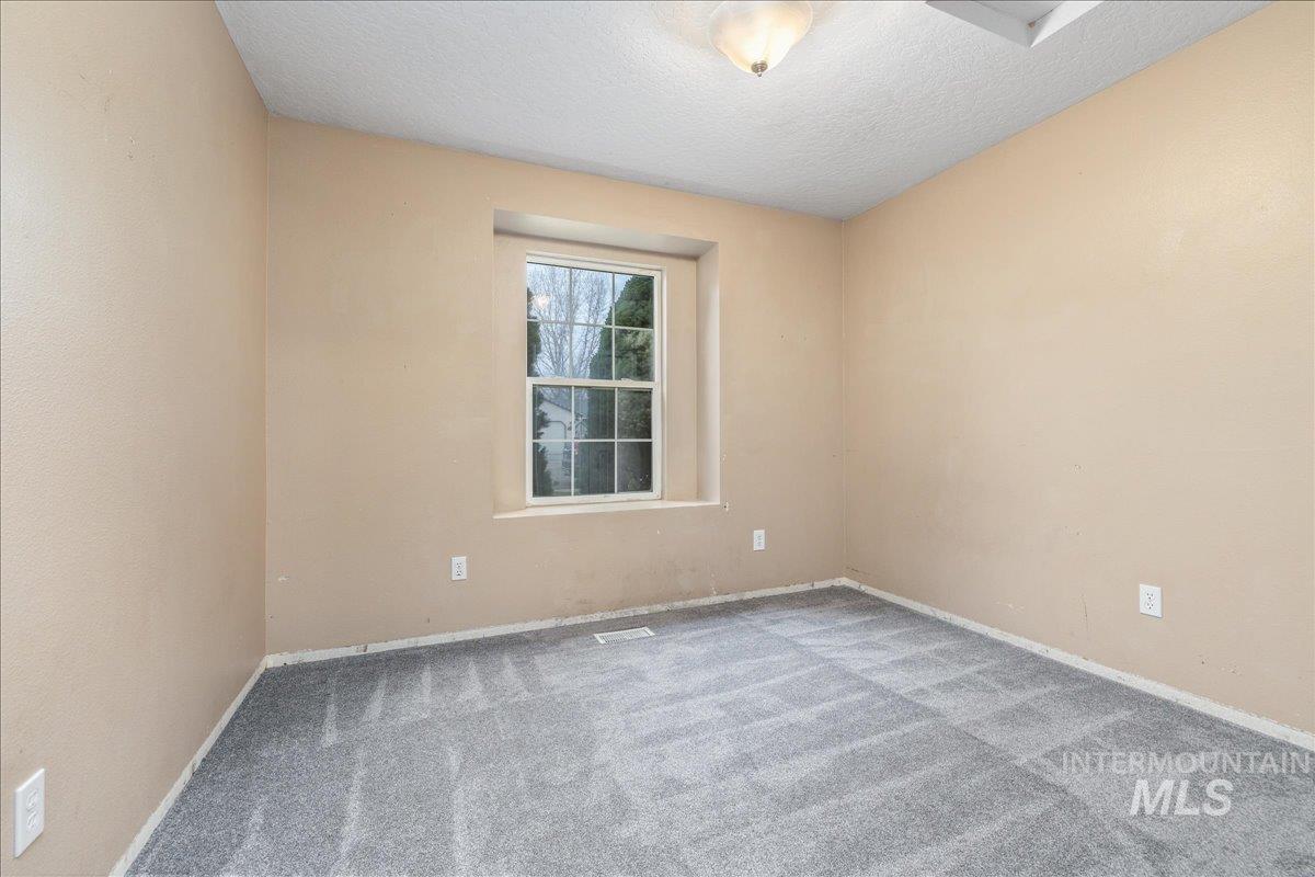Carpeted bedroom with baseboards and a textured ceiling