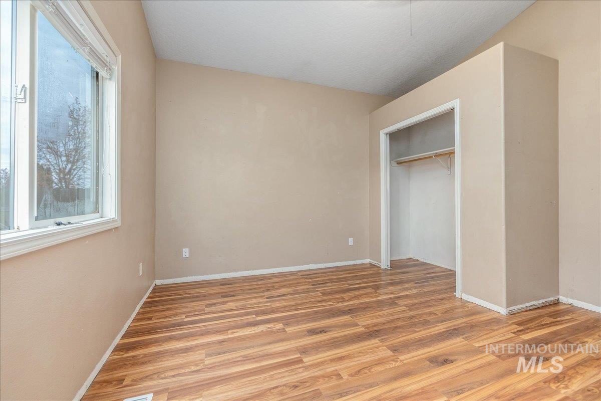 Unfurnished bedroom with light wood-type flooring and a closet