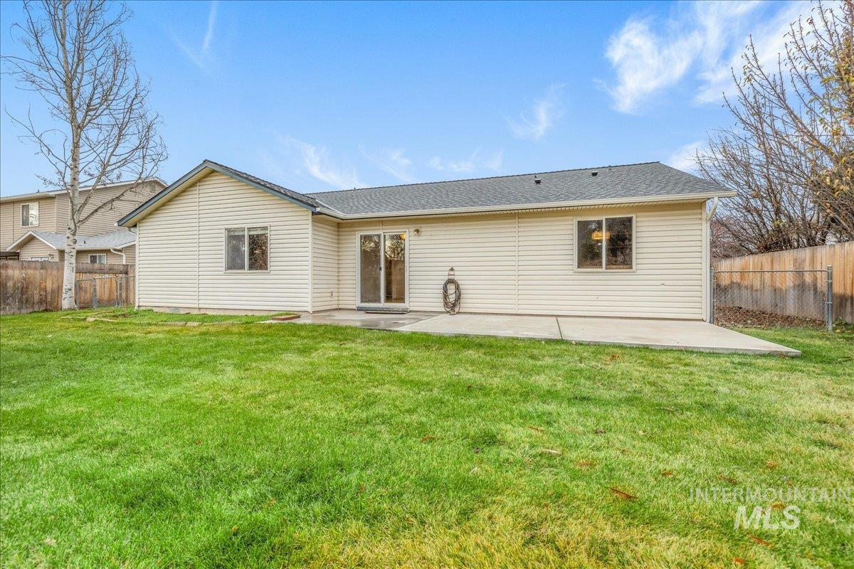 Rear view of property featuring a fenced backyard, a patio area, and roof with shingles