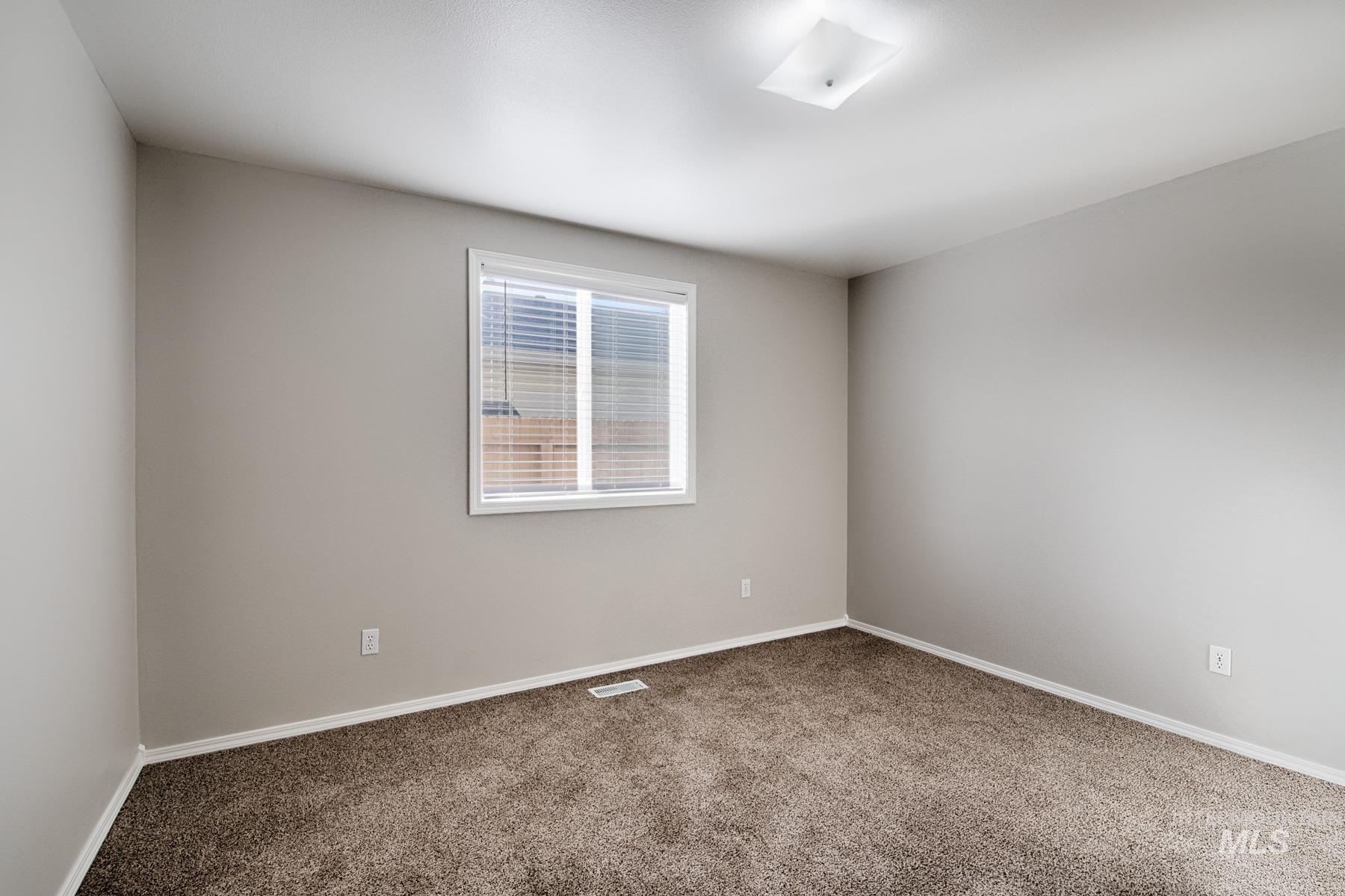 Carpeted spare room featuring baseboards