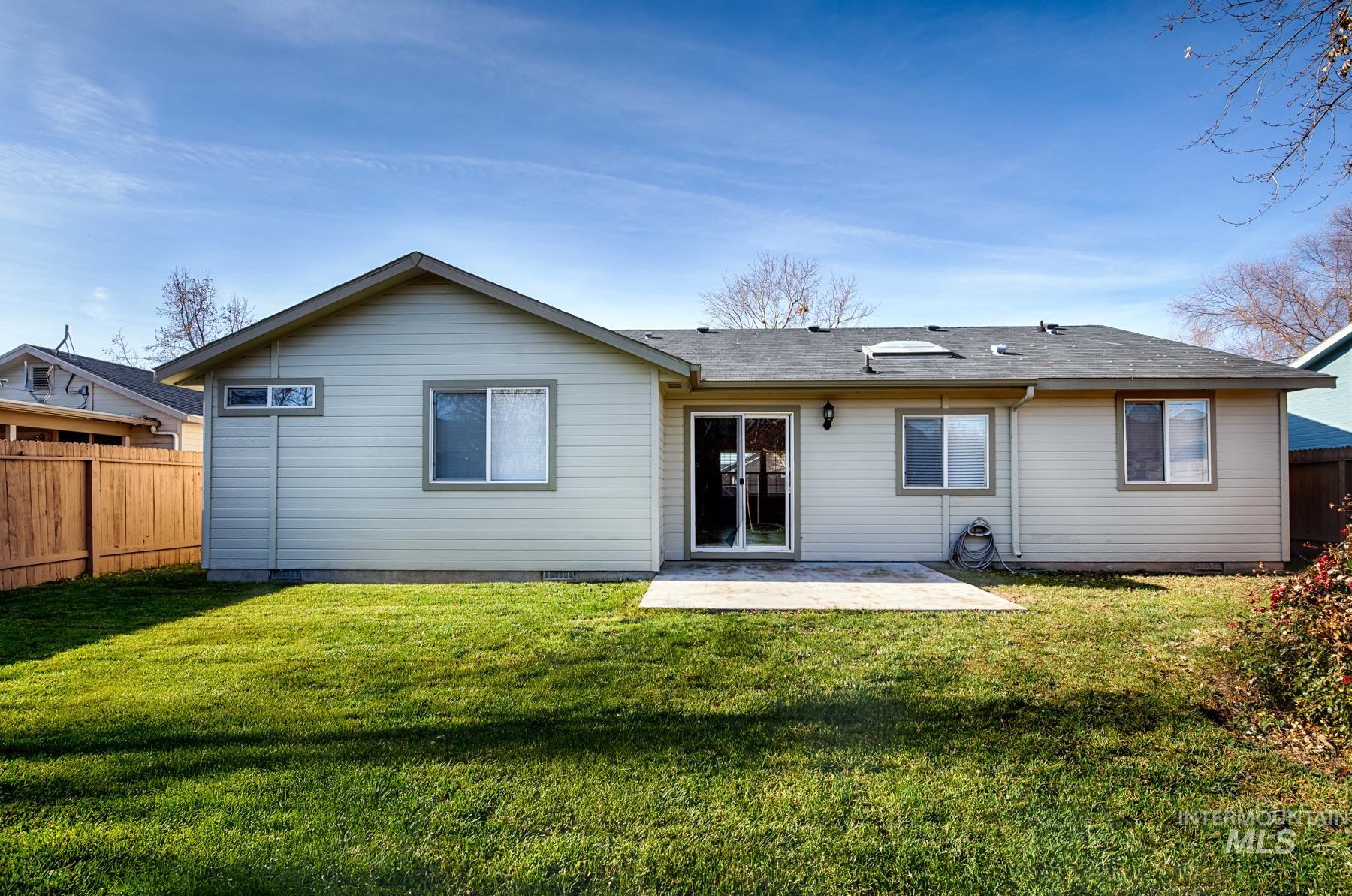 Back of house with a fenced backyard, a patio area, and a shingled roof