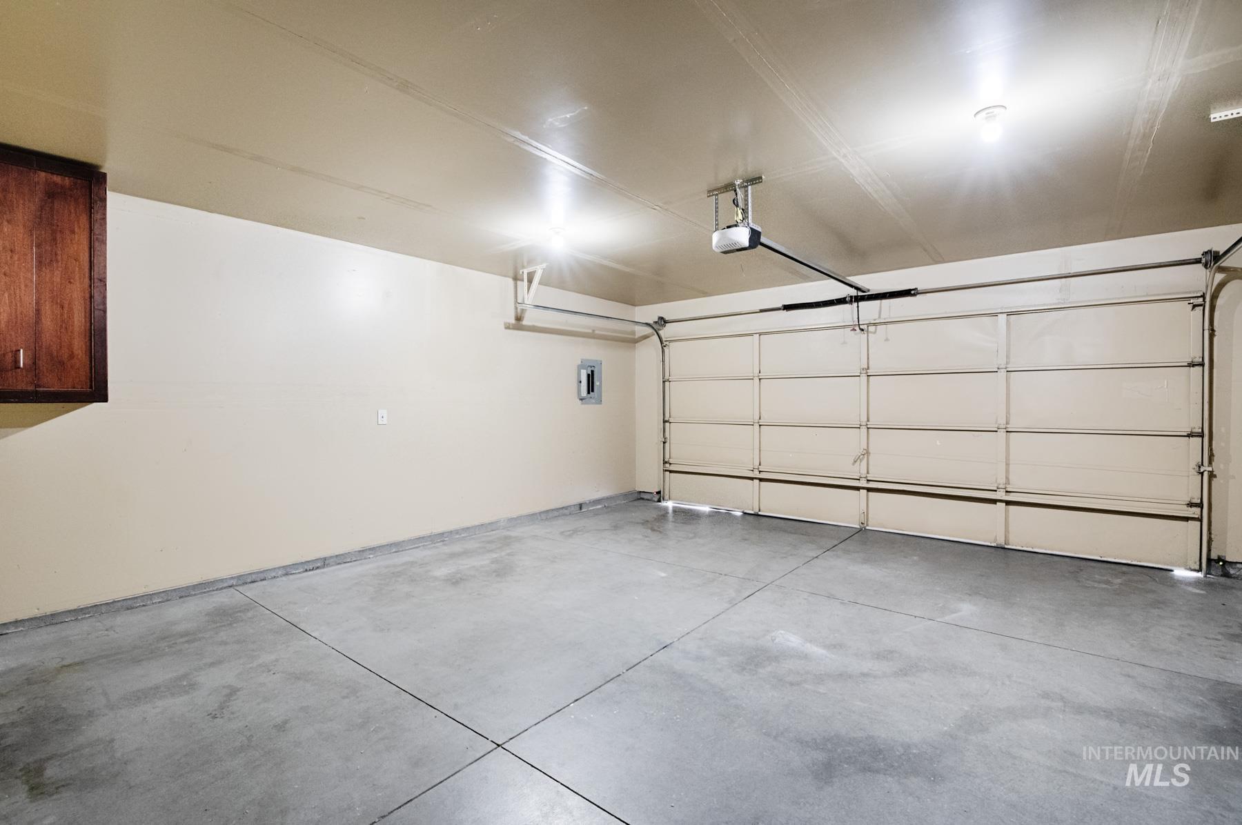Garage featuring electric panel and a garage door opener