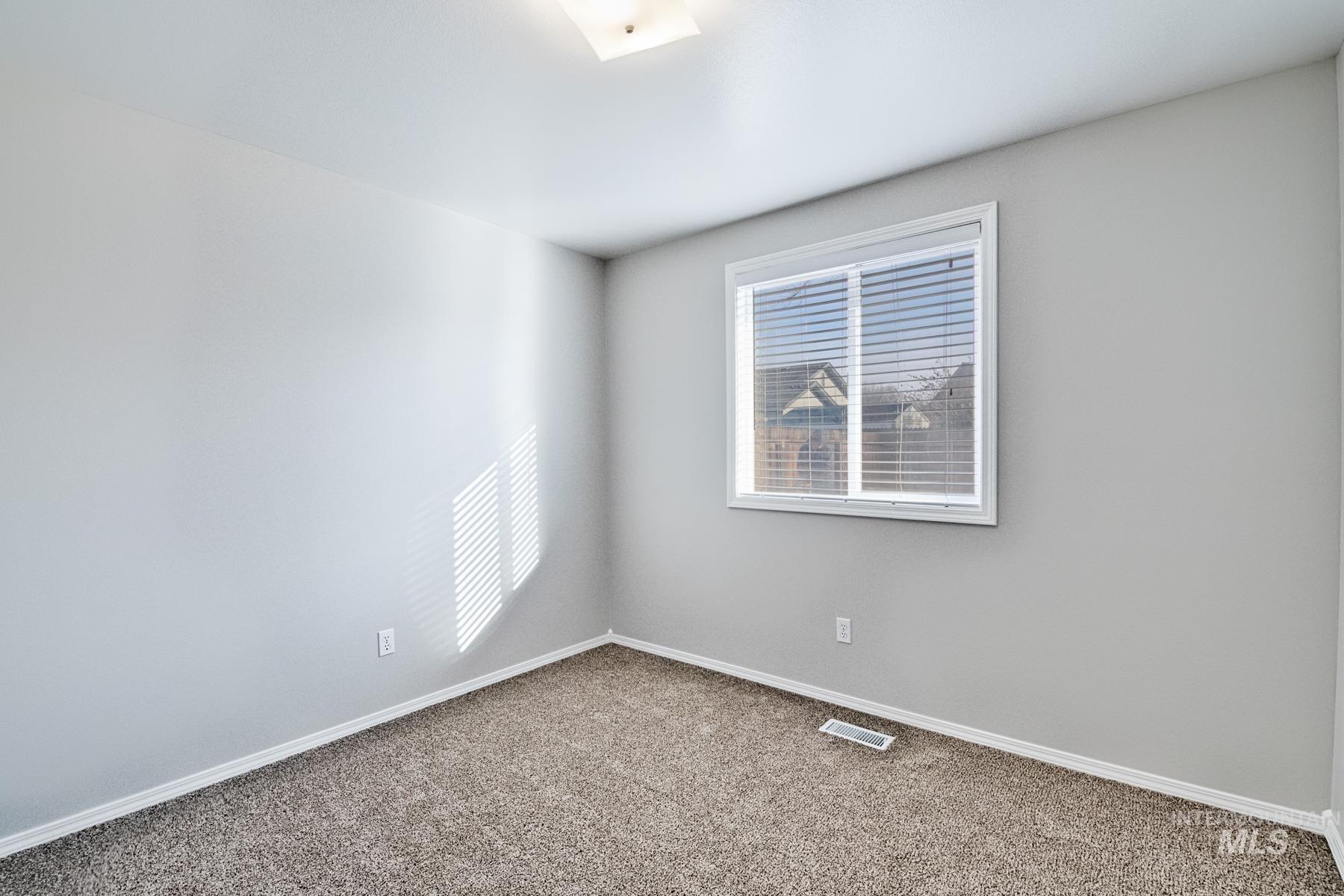 Empty room featuring baseboards and carpet flooring