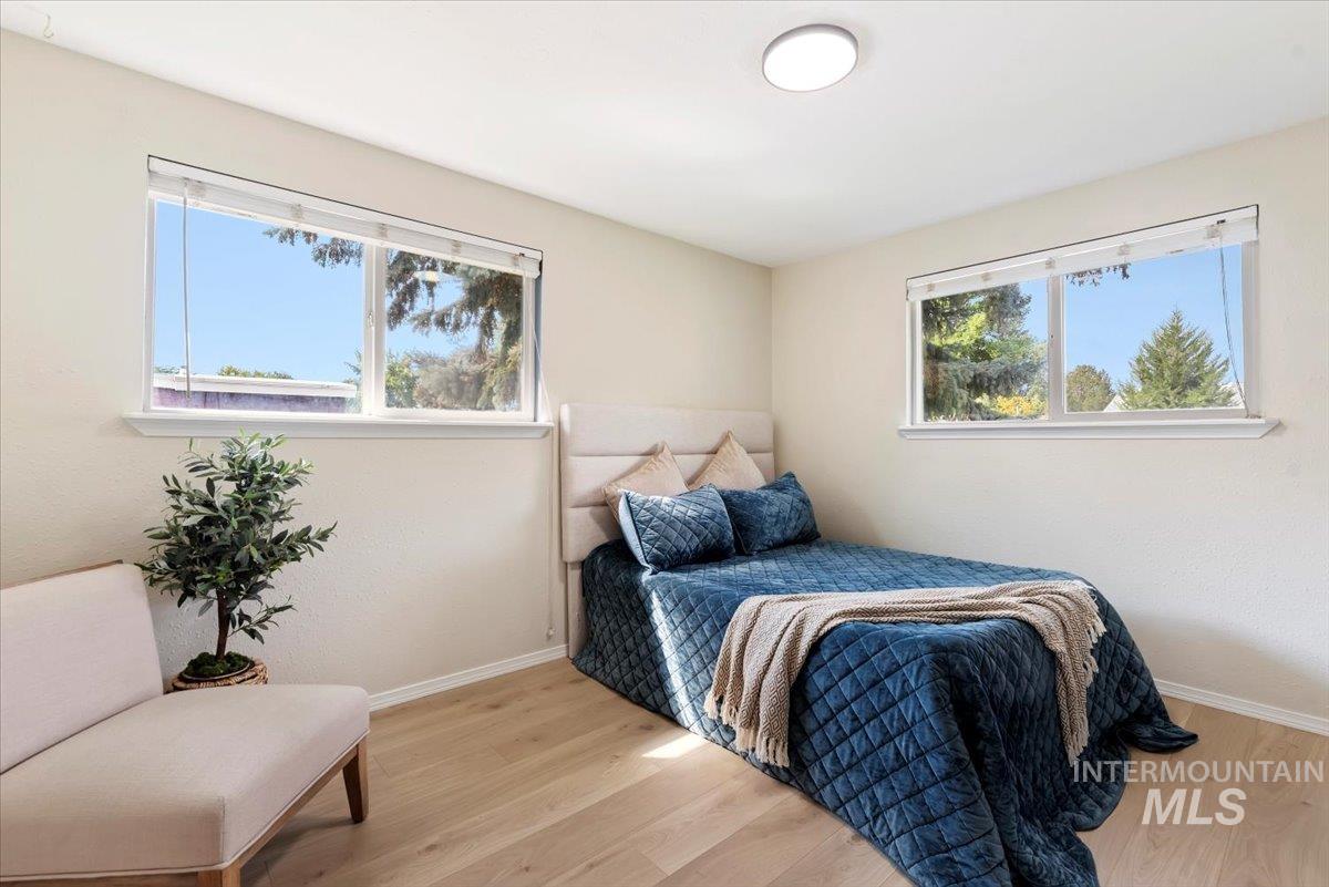 Bedroom with light wood-type flooring and multiple windows