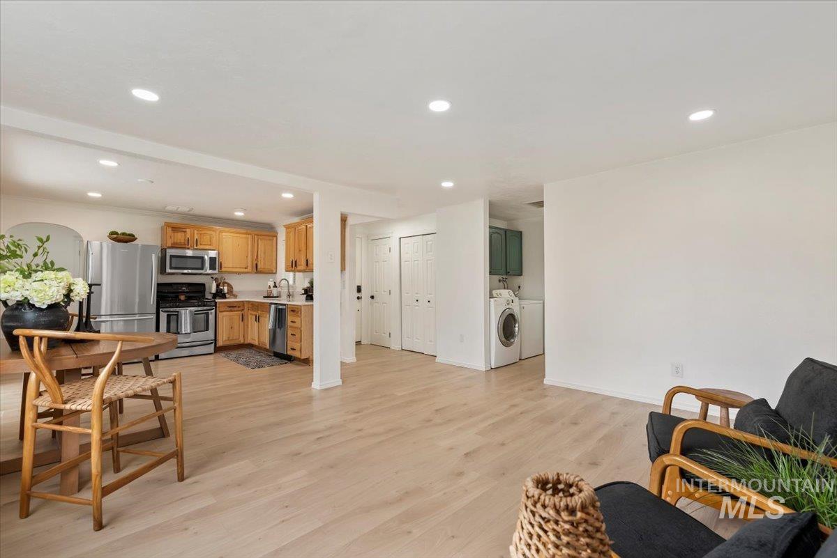 Living room featuring recessed lighting, light wood-type flooring, and washing machine and clothes dryer