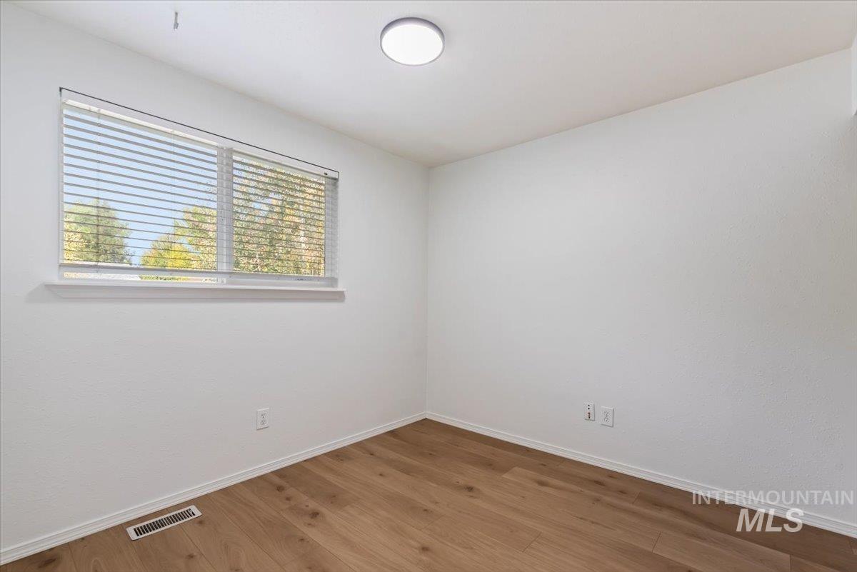 Empty room featuring baseboards and wood finished floors
