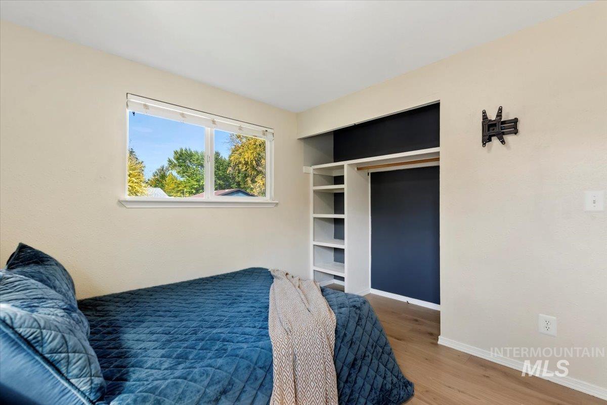 Bedroom with wood finished floors and baseboards