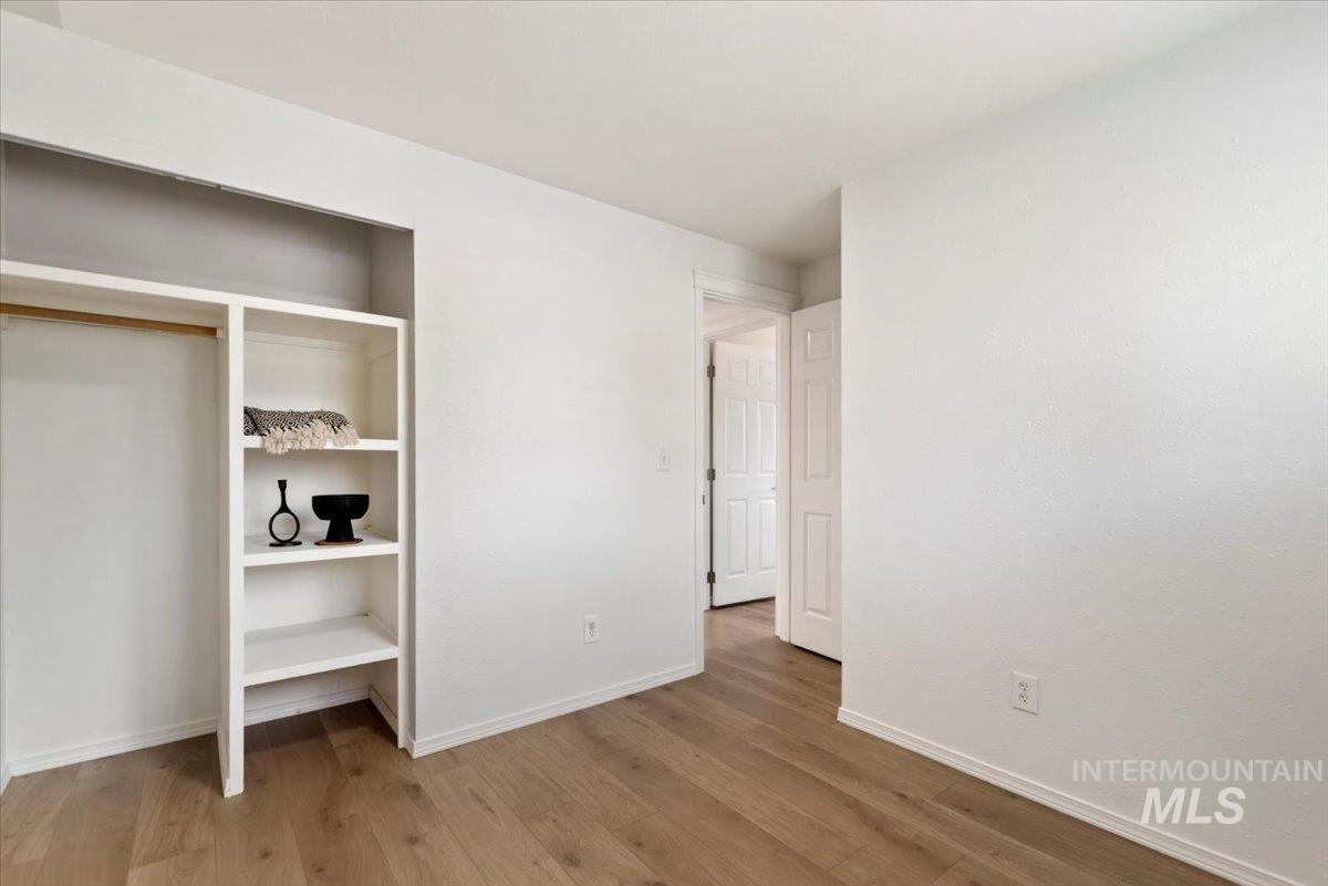 Unfurnished bedroom with light wood-type flooring and a closet