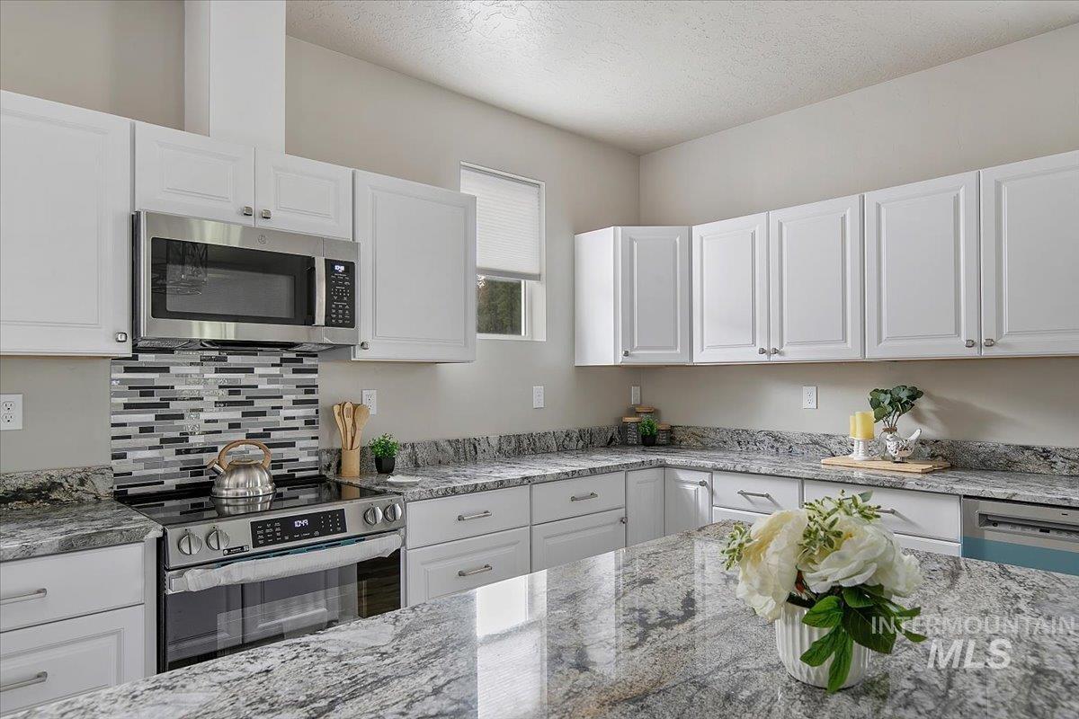 Kitchen with stainless steel appliances and island with breakfast bar