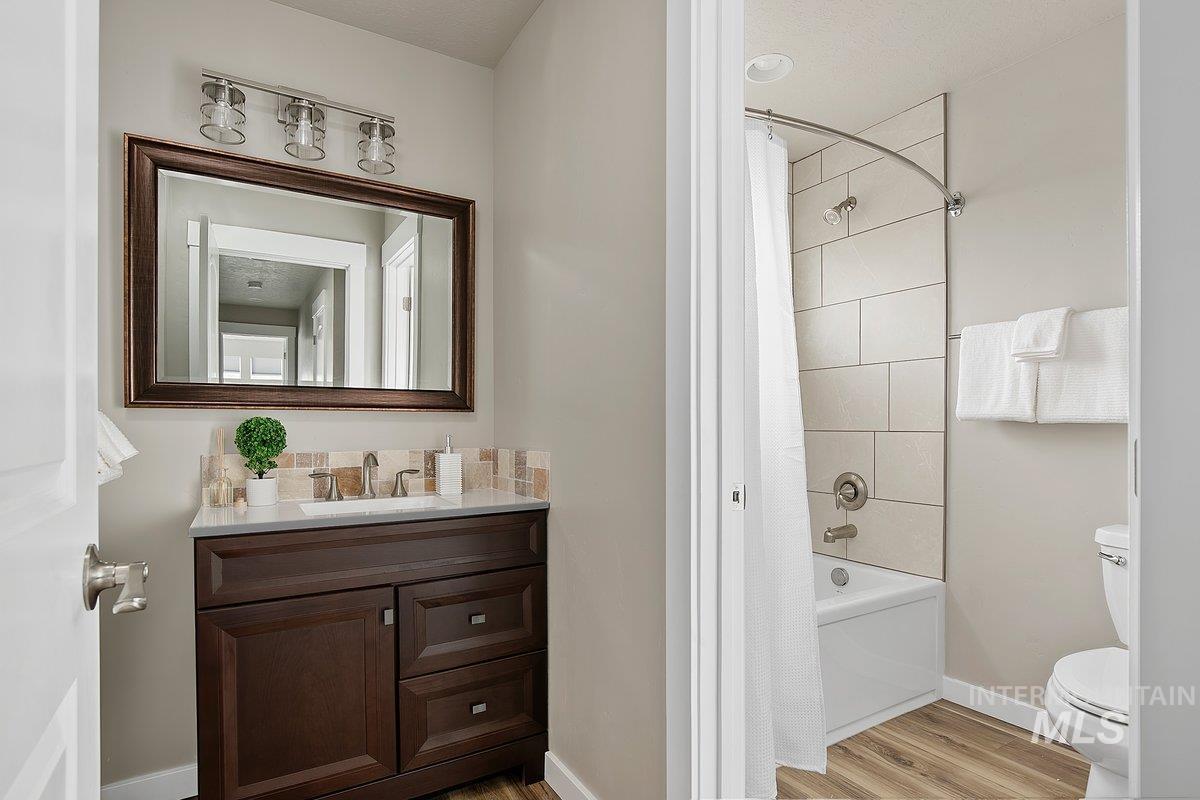 Full bath with vanity, wood finished floors, and shower / tub combo, upper level