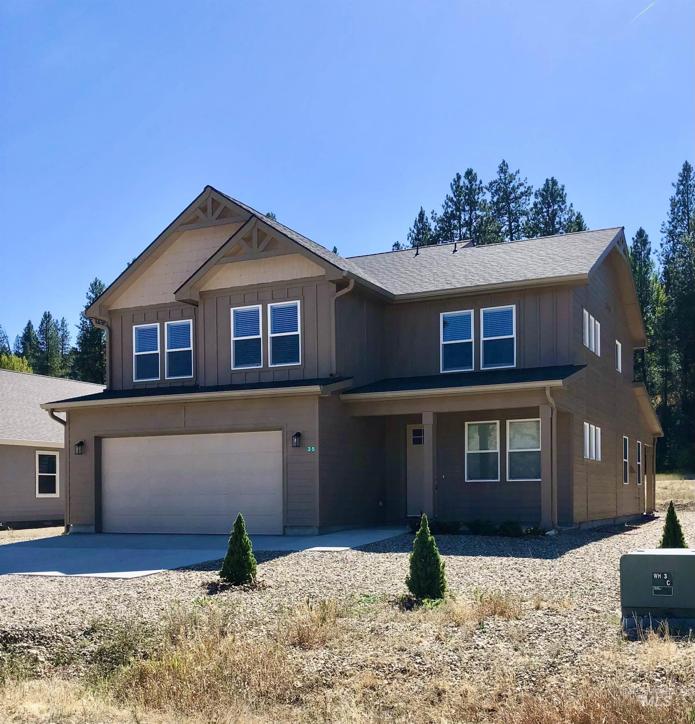 Craftsman-style house with a garage, driveway, and board and batten siding