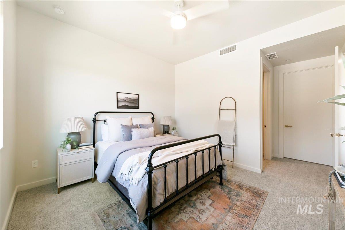 Bedroom featuring light colored carpet and ceiling fan