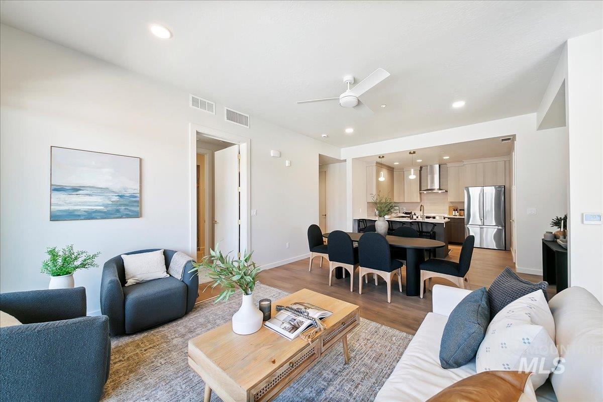 Living room with recessed lighting, a ceiling fan, and light wood finished floors