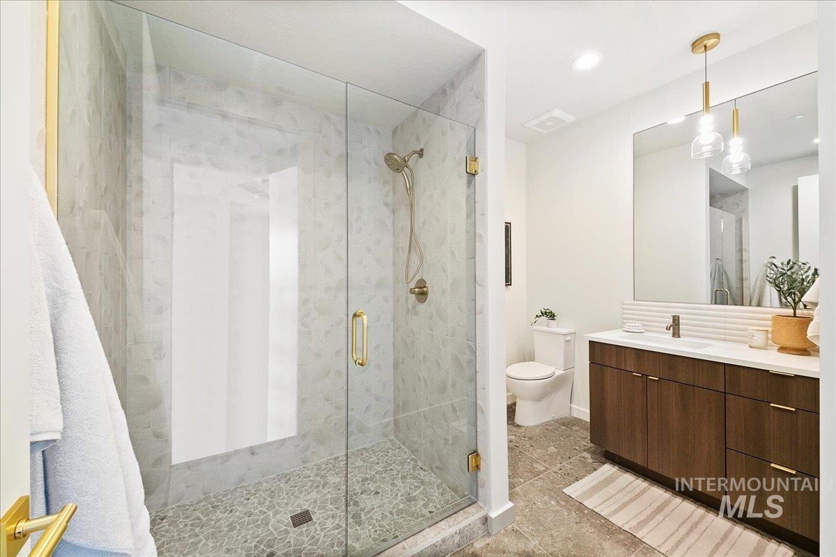 Bathroom featuring vanity, a stall shower, and recessed lighting