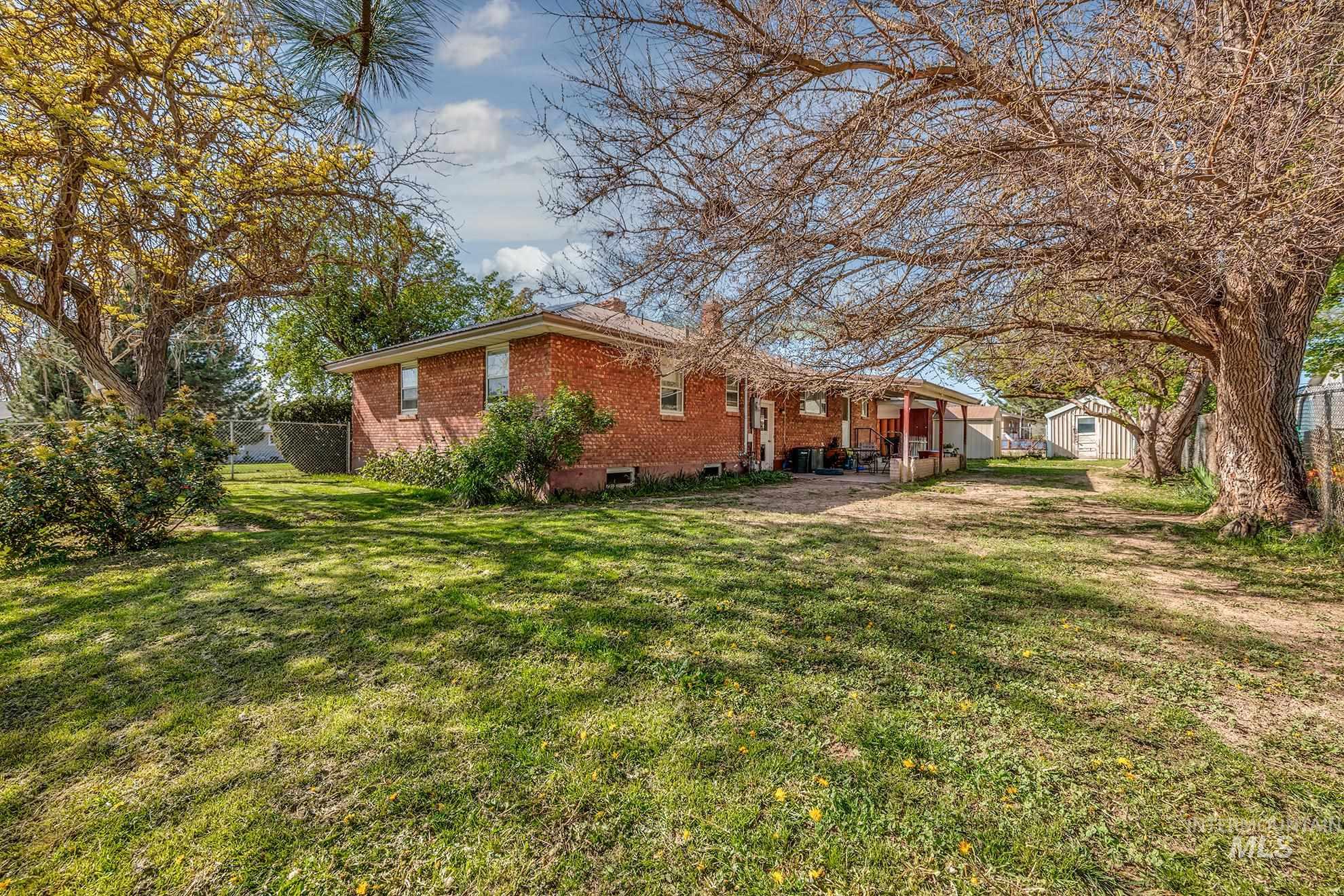 View of home's exterior with brick siding, a patio, and a storage unit