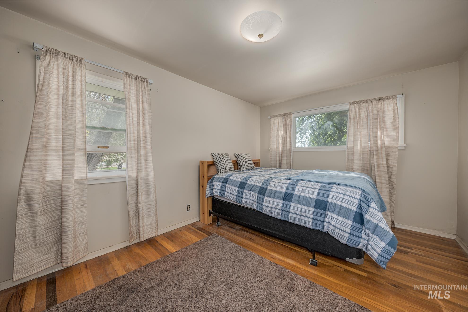 Bedroom featuring wood-type flooring and baseboards