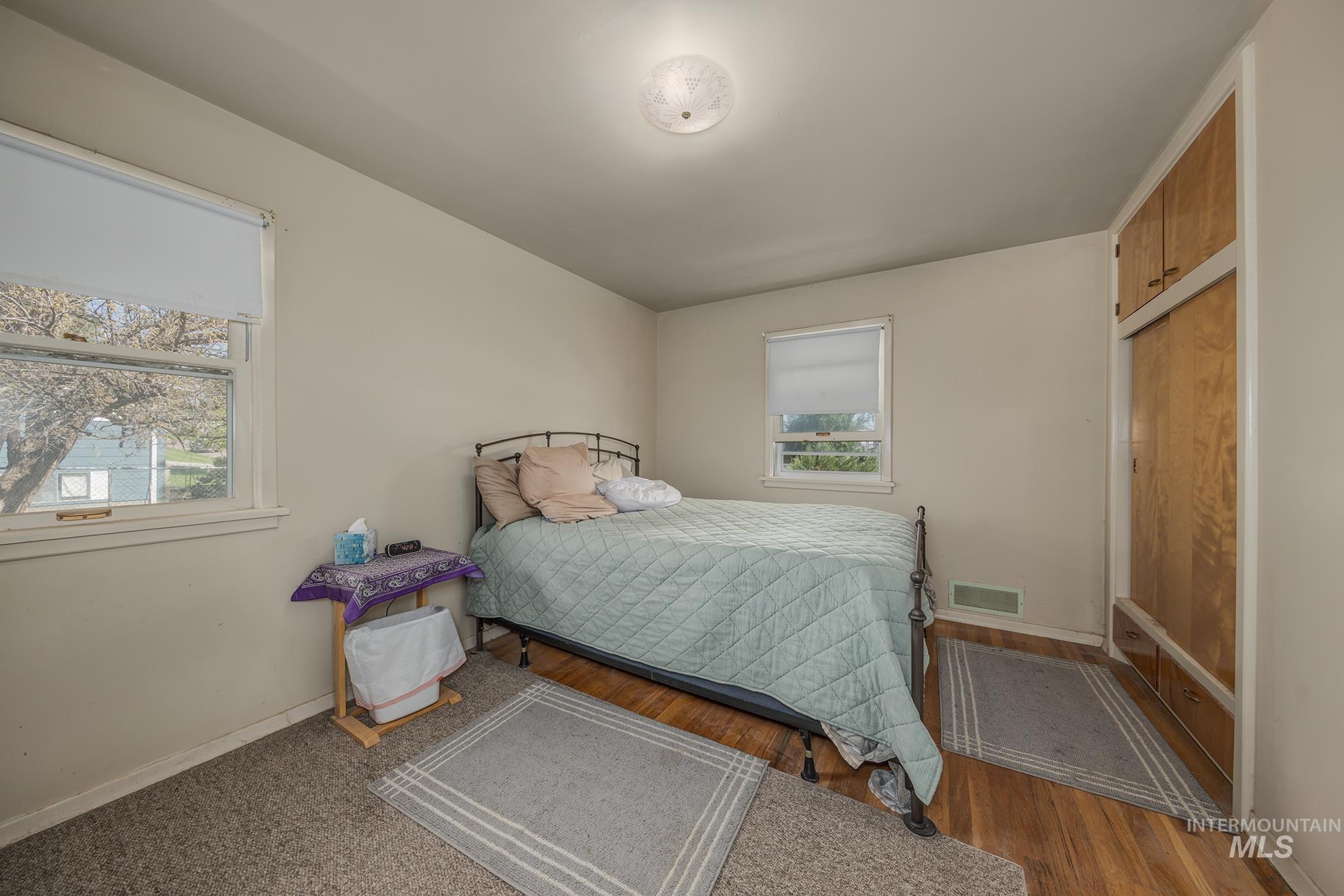 Bedroom with baseboards and wood finished floors