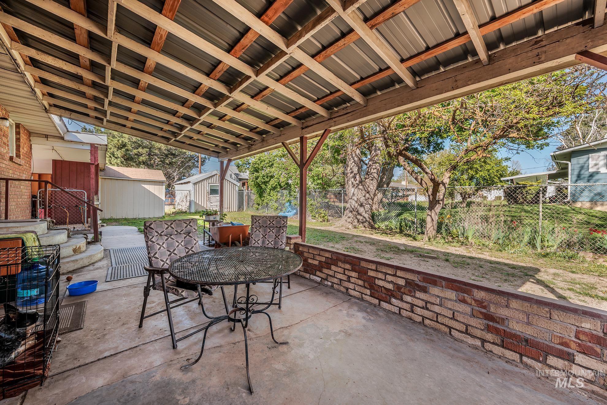 Fenced backyard featuring a storage shed, a patio area, and outdoor dining area
