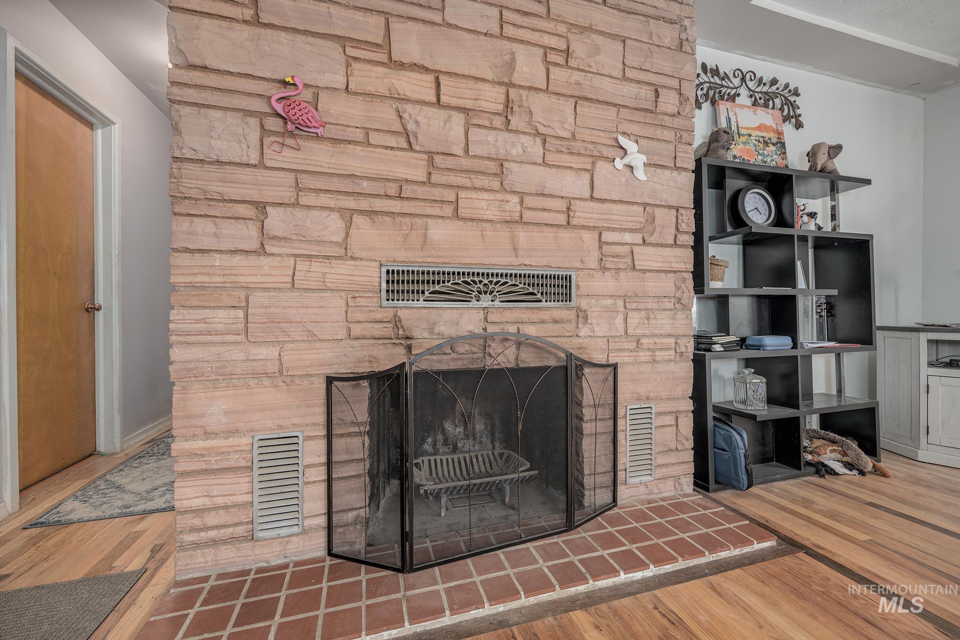 Detailed view of a stone fireplace and wood finished floors