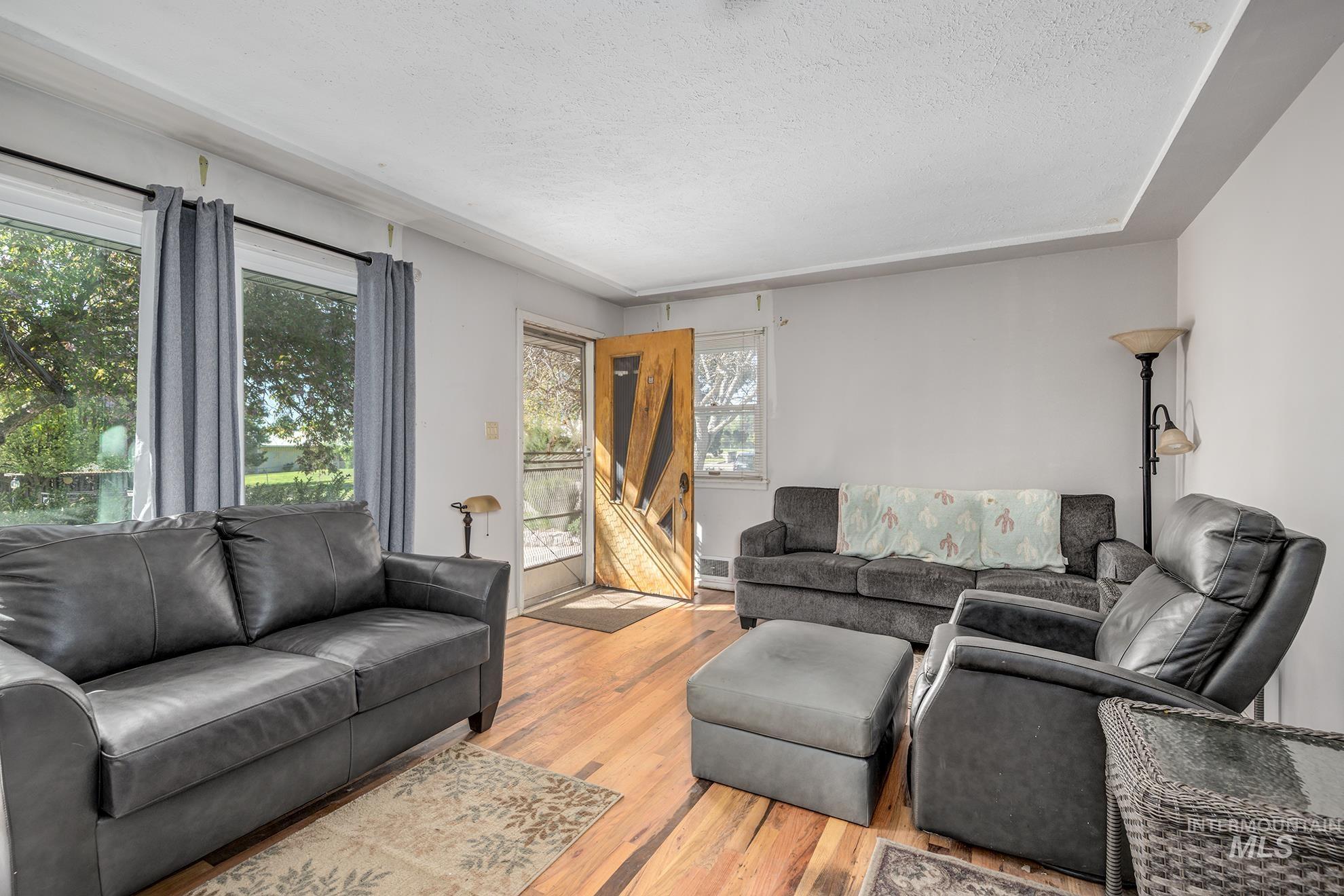 Living area featuring light wood-type flooring and a textured ceiling