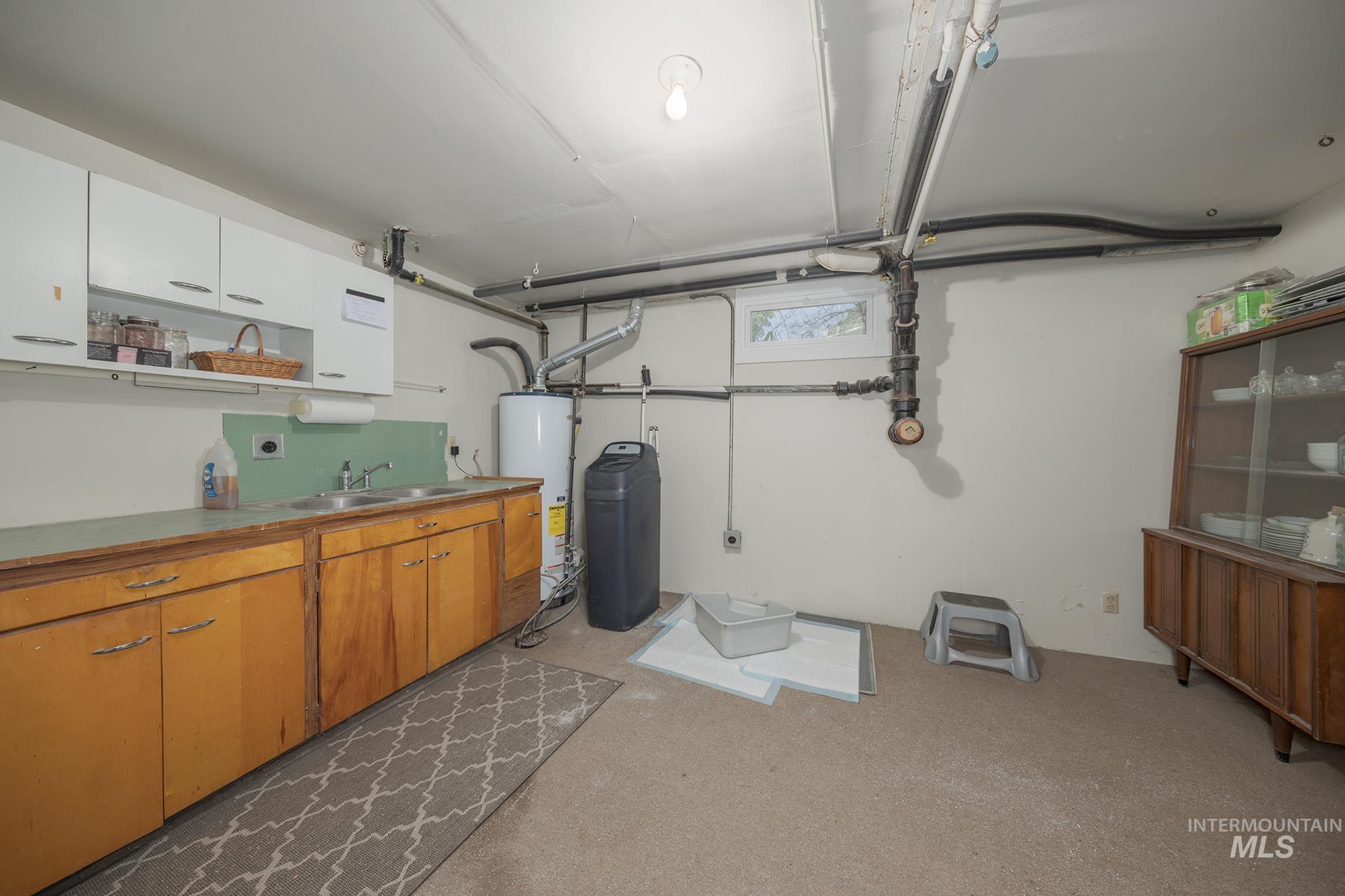 Below grade area with a water softener and water heater