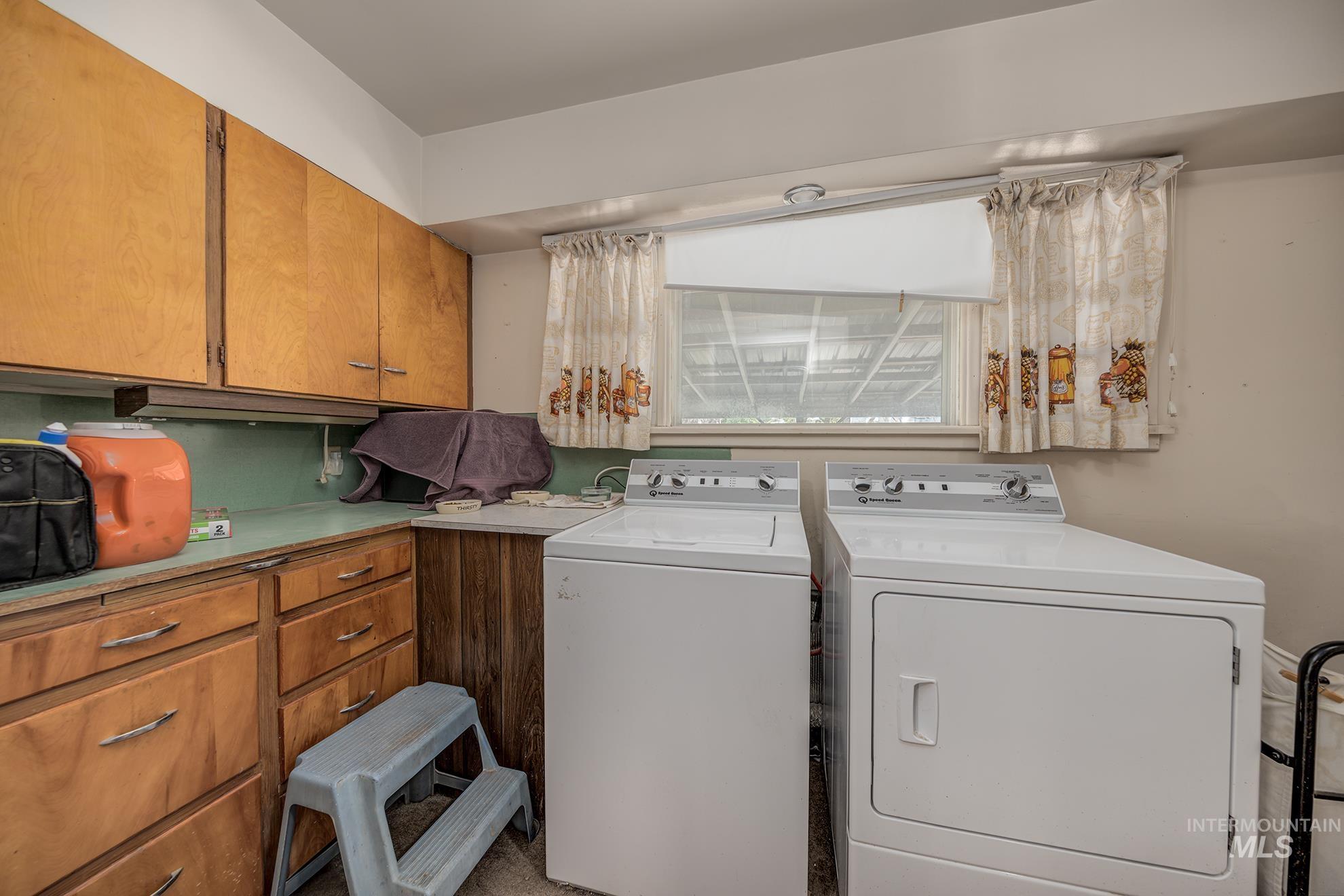 Laundry room with separate washer and dryer and cabinet space