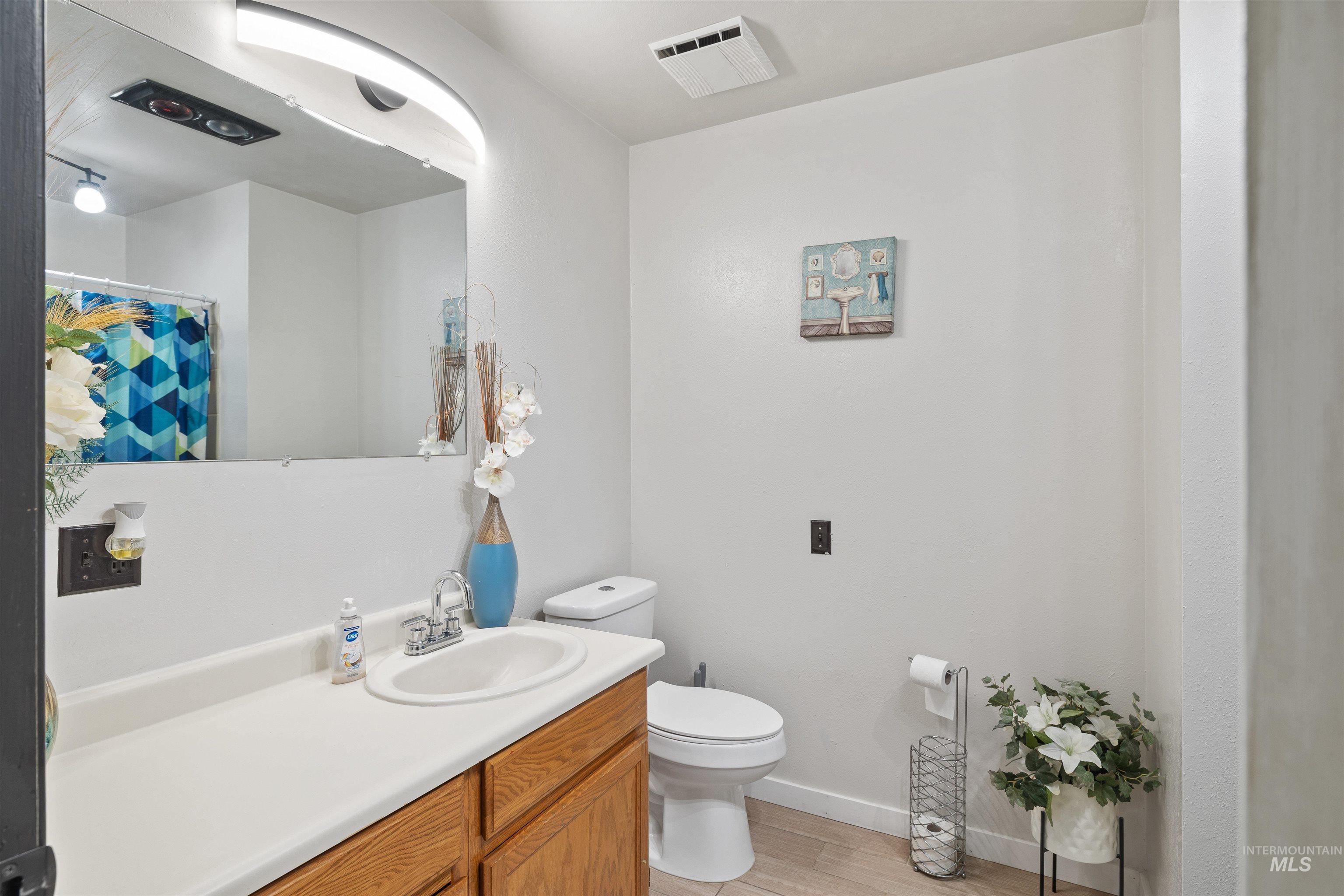Bathroom featuring vanity, light wood-style floors, and a shower with curtain