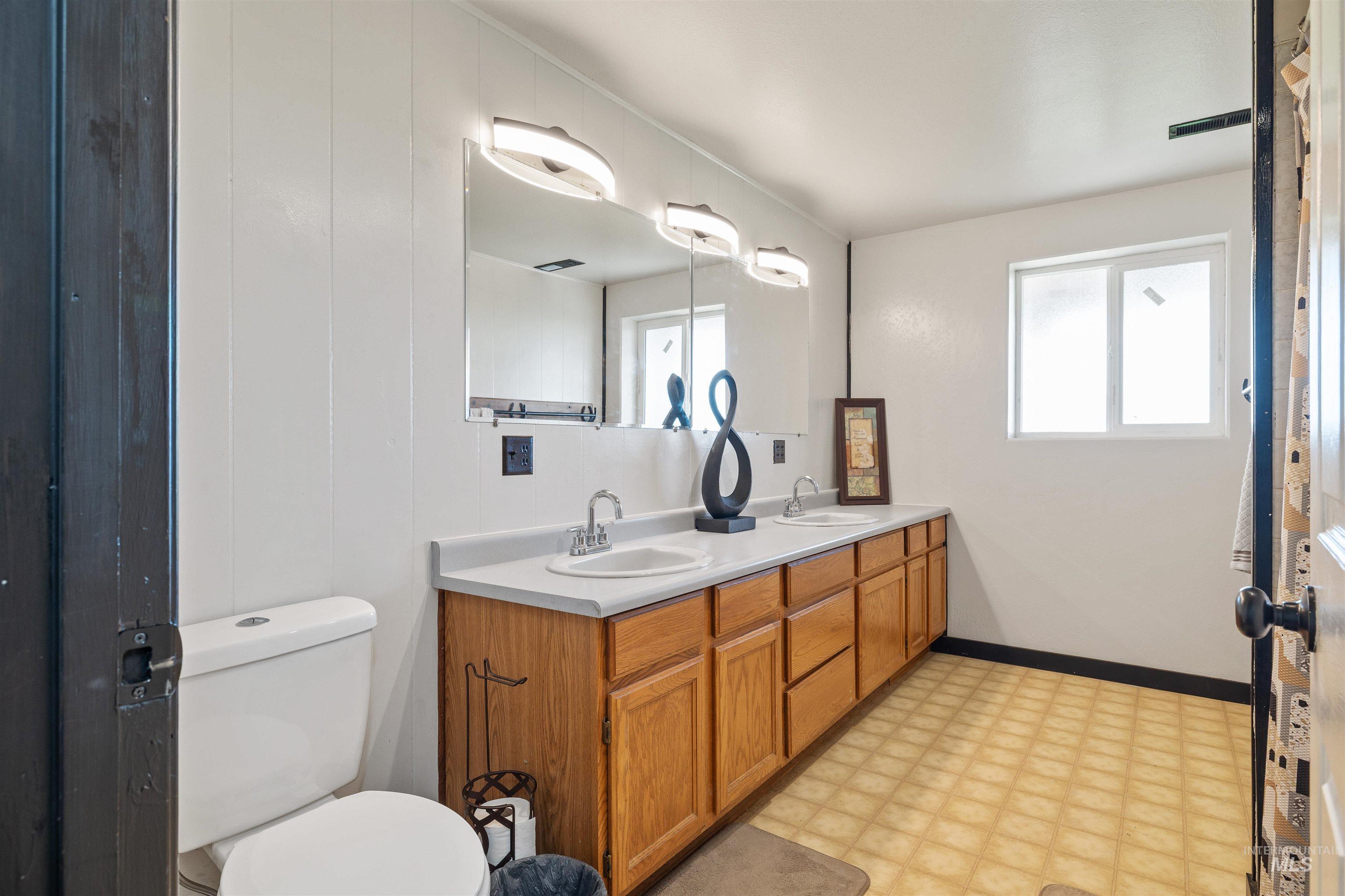 Bathroom with light flooring and double vanity