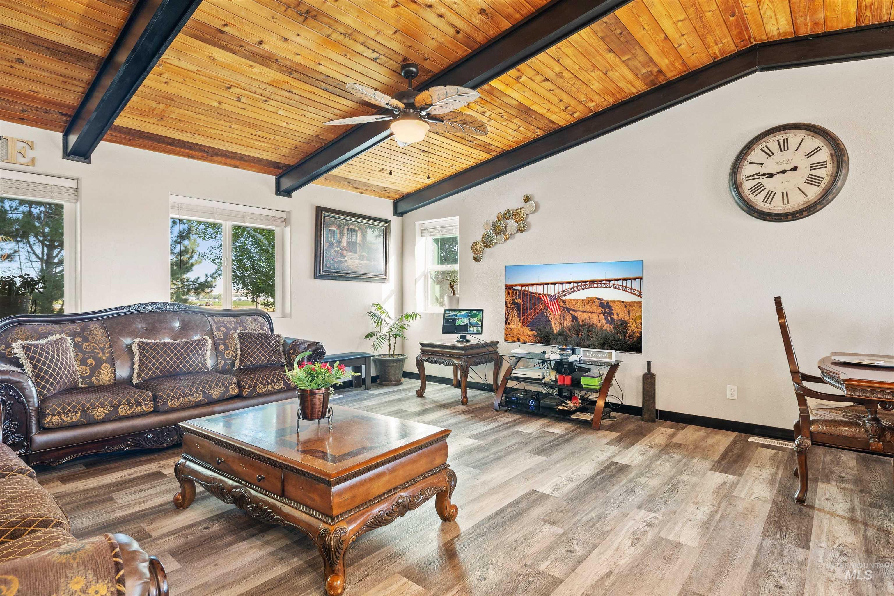 Living room with wooden ceiling, wood finished floors, and a ceiling fan