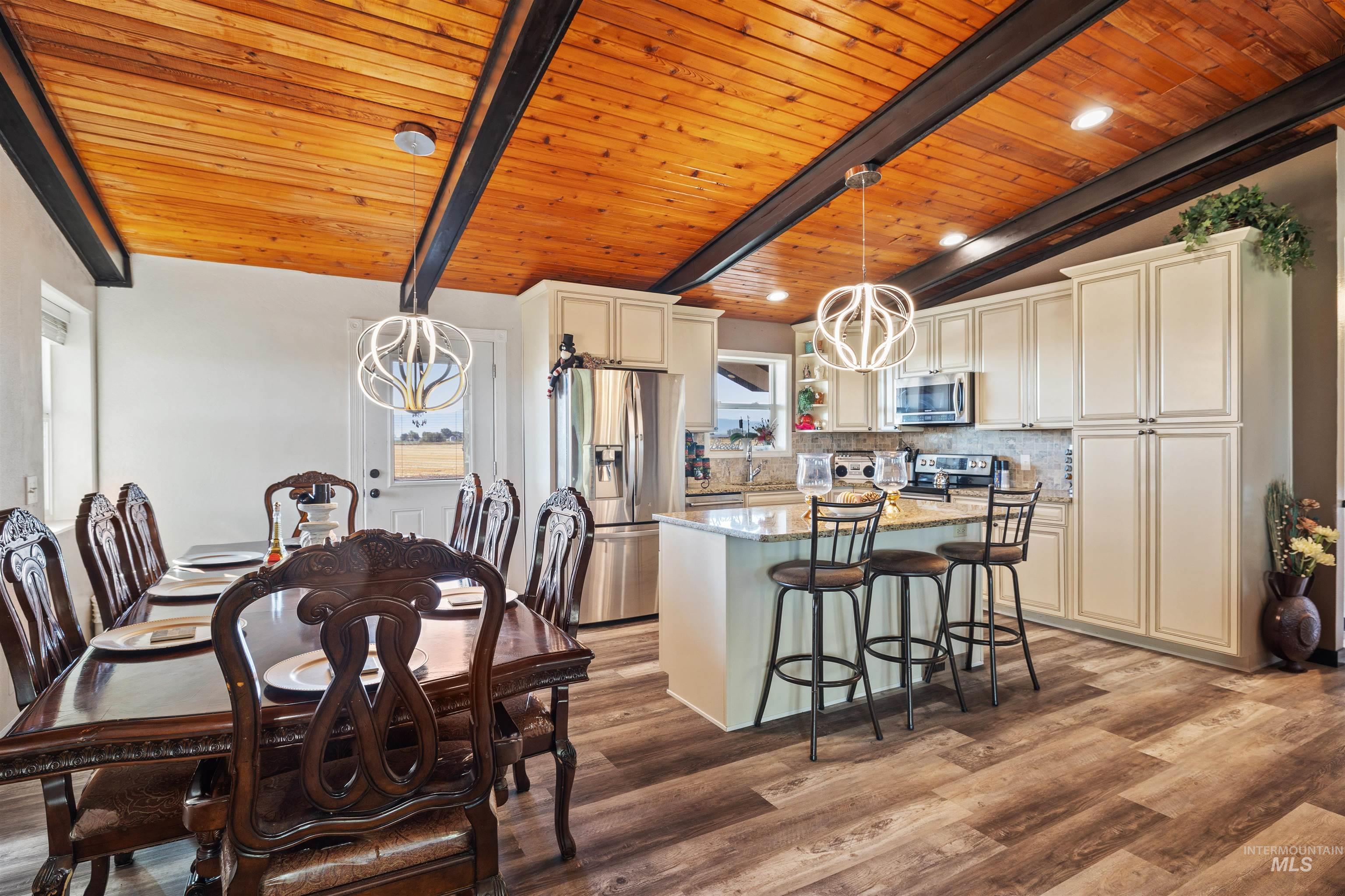 Kitchen featuring a chandelier, light stone counters, decorative backsplash, pendant lighting, and wood ceiling