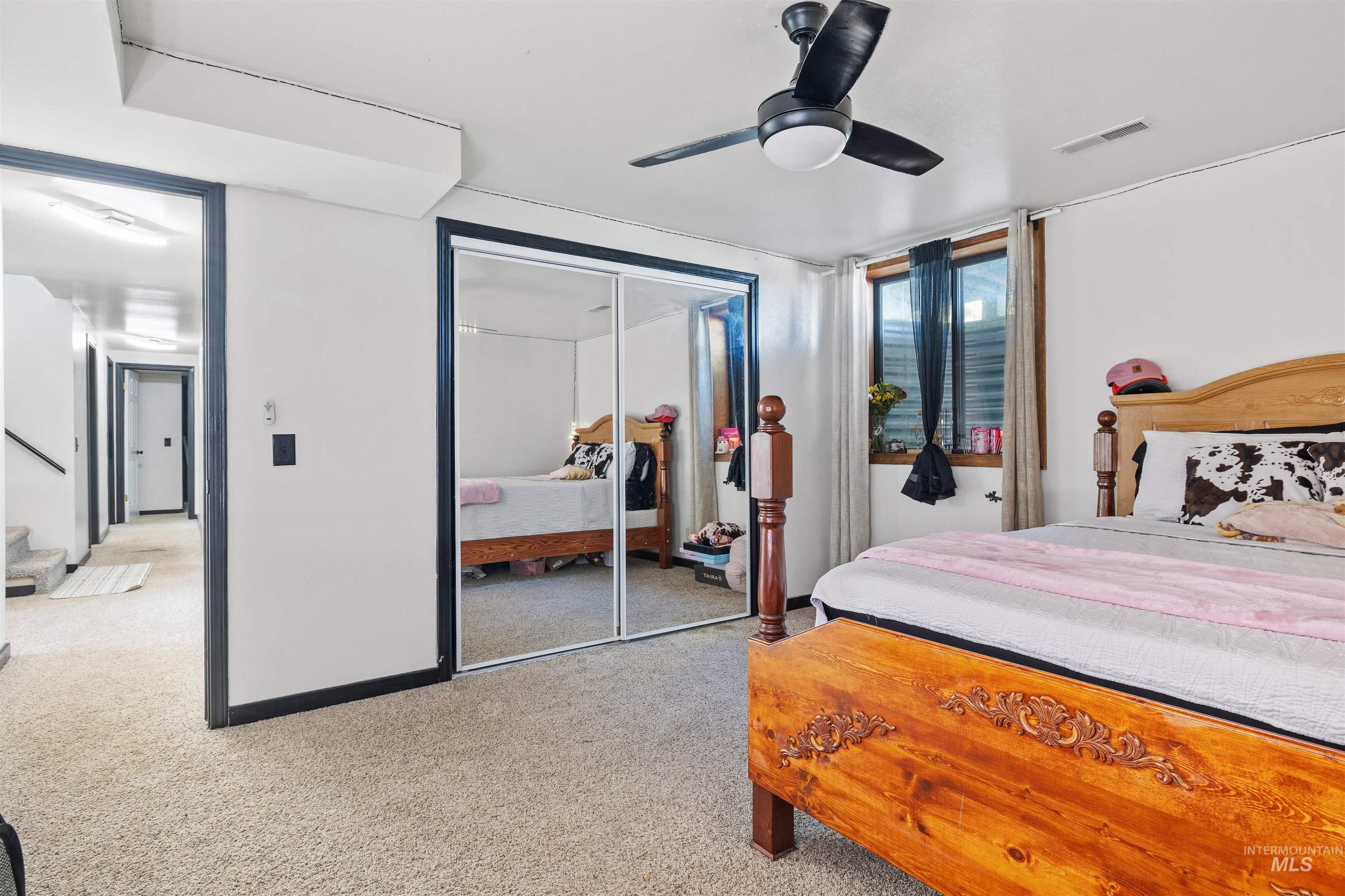 Bedroom with carpet, ceiling fan, and a closet