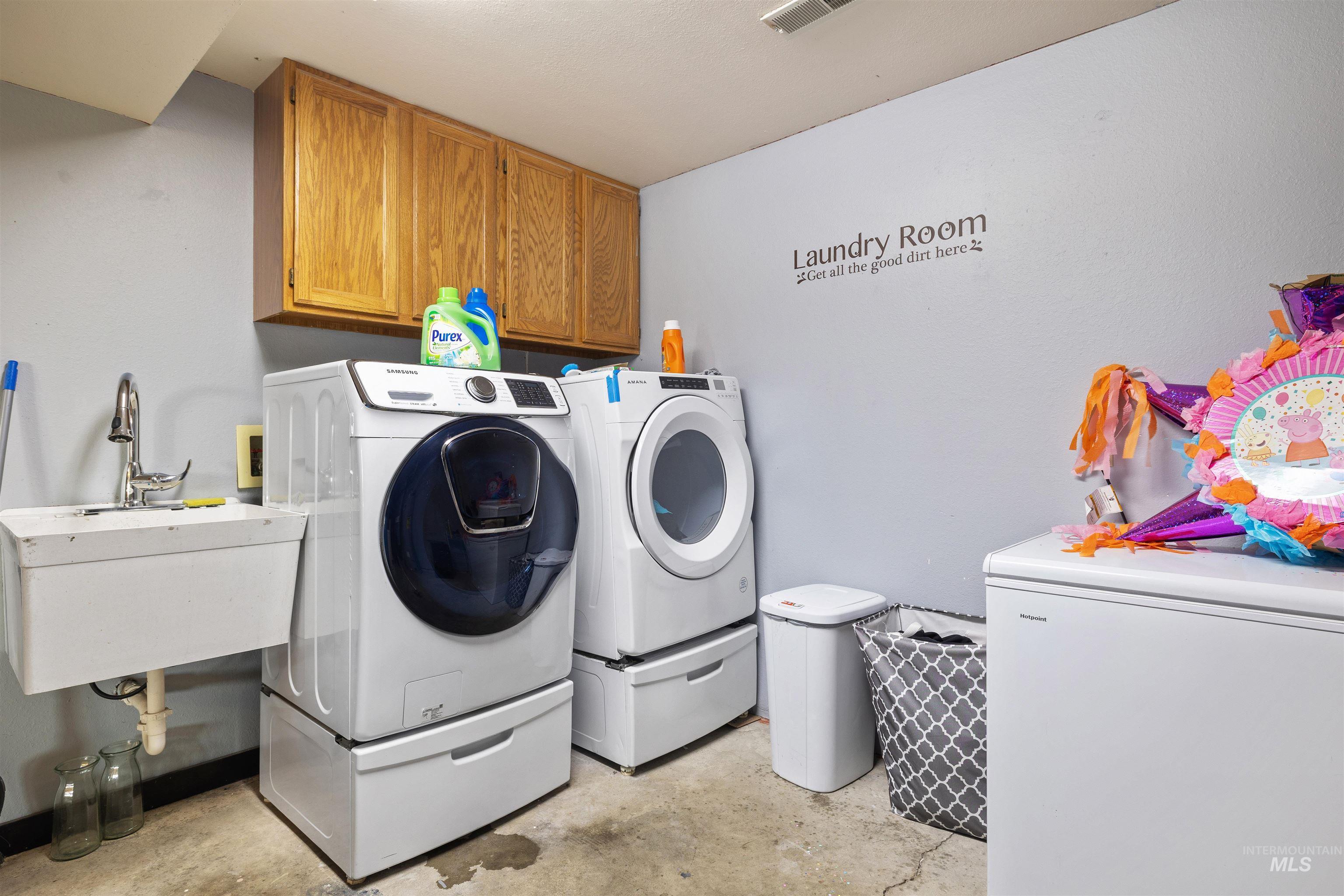 Washroom featuring washer and dryer and cabinet space