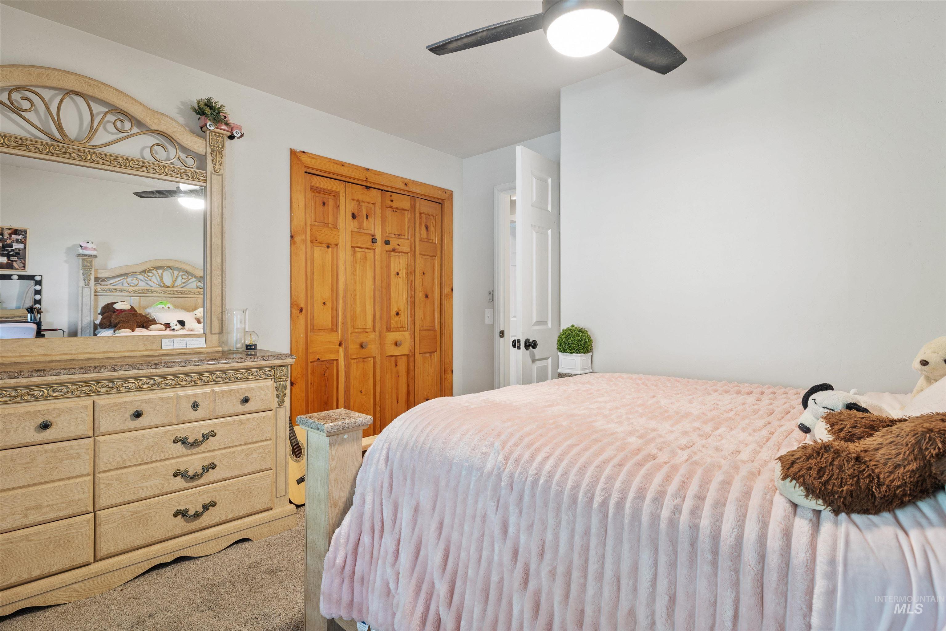 Carpeted bedroom featuring a closet and a ceiling fan