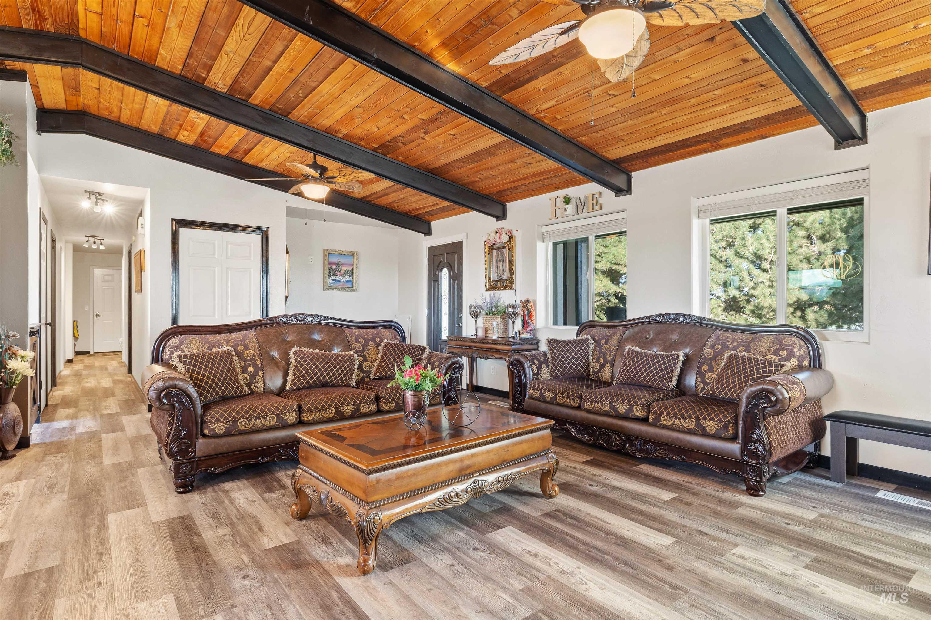 Living room featuring wooden ceiling, ceiling fan, and light wood-style floors