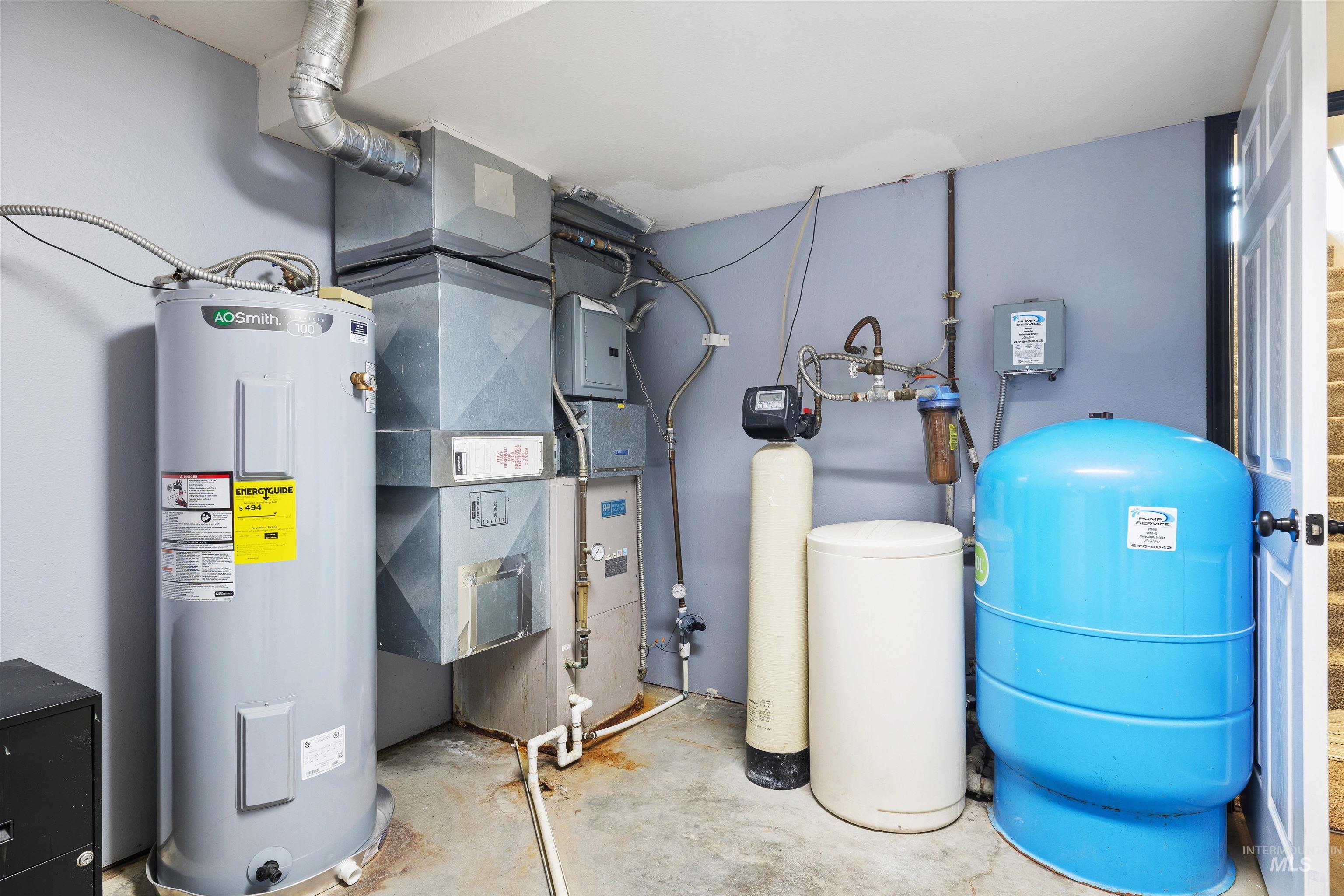 Utility room featuring water heater and heating unit