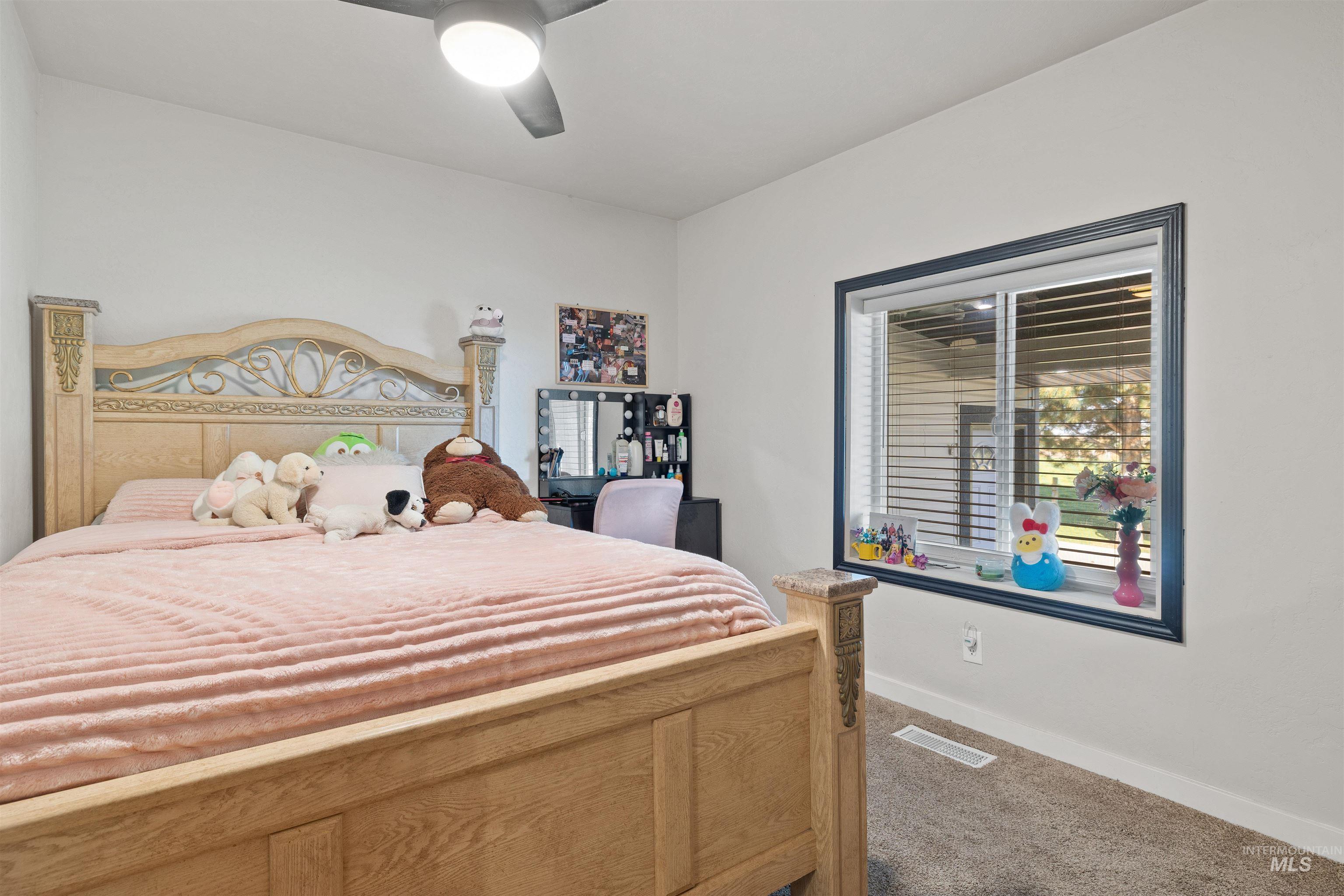 Carpeted bedroom featuring baseboards and a ceiling fan