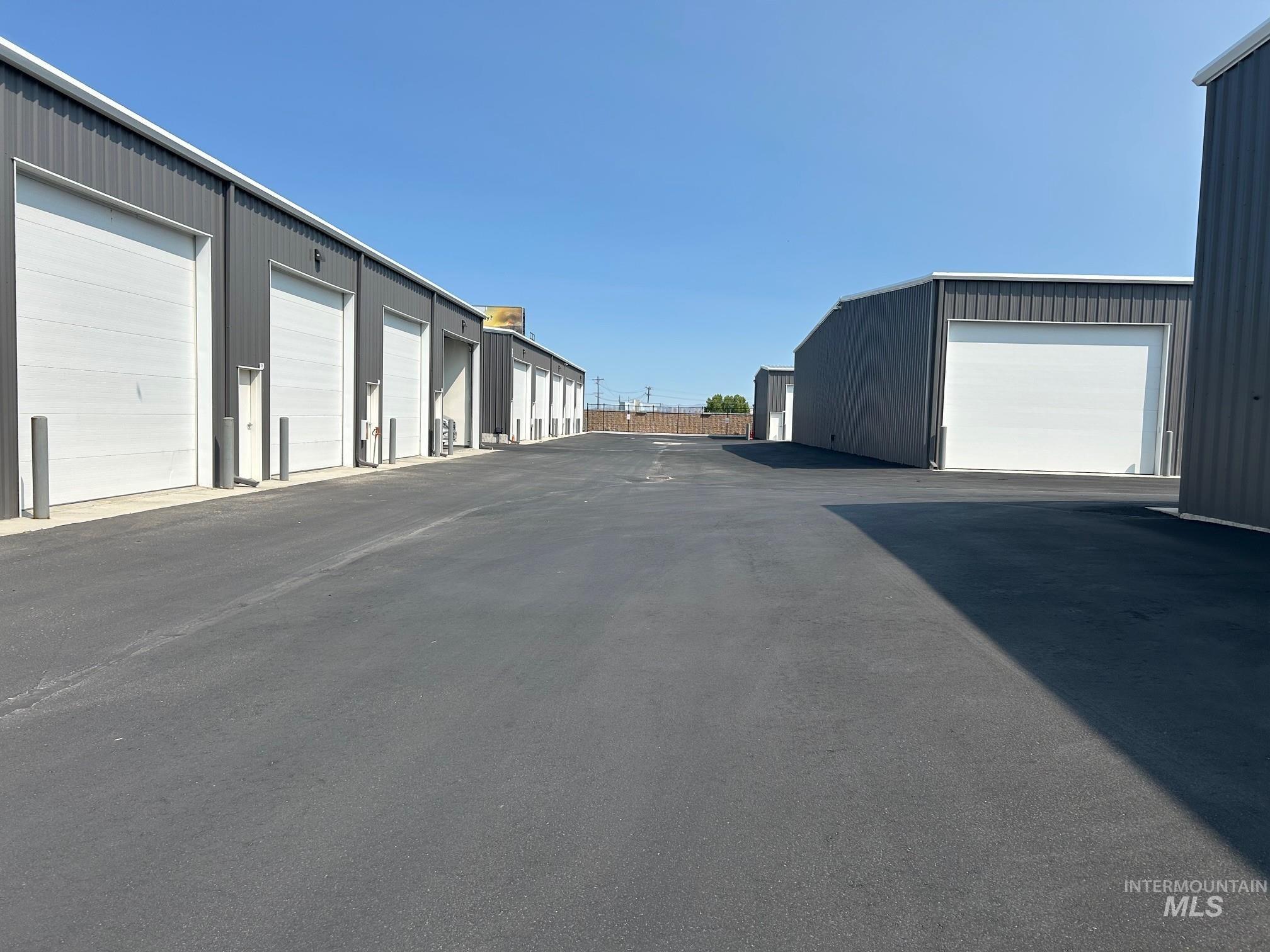 View of asphalt road featuring community garages