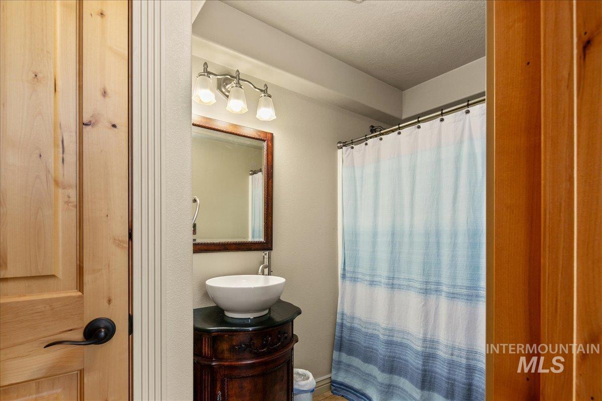 Full bathroom featuring vanity, a textured ceiling, and a shower with curtain