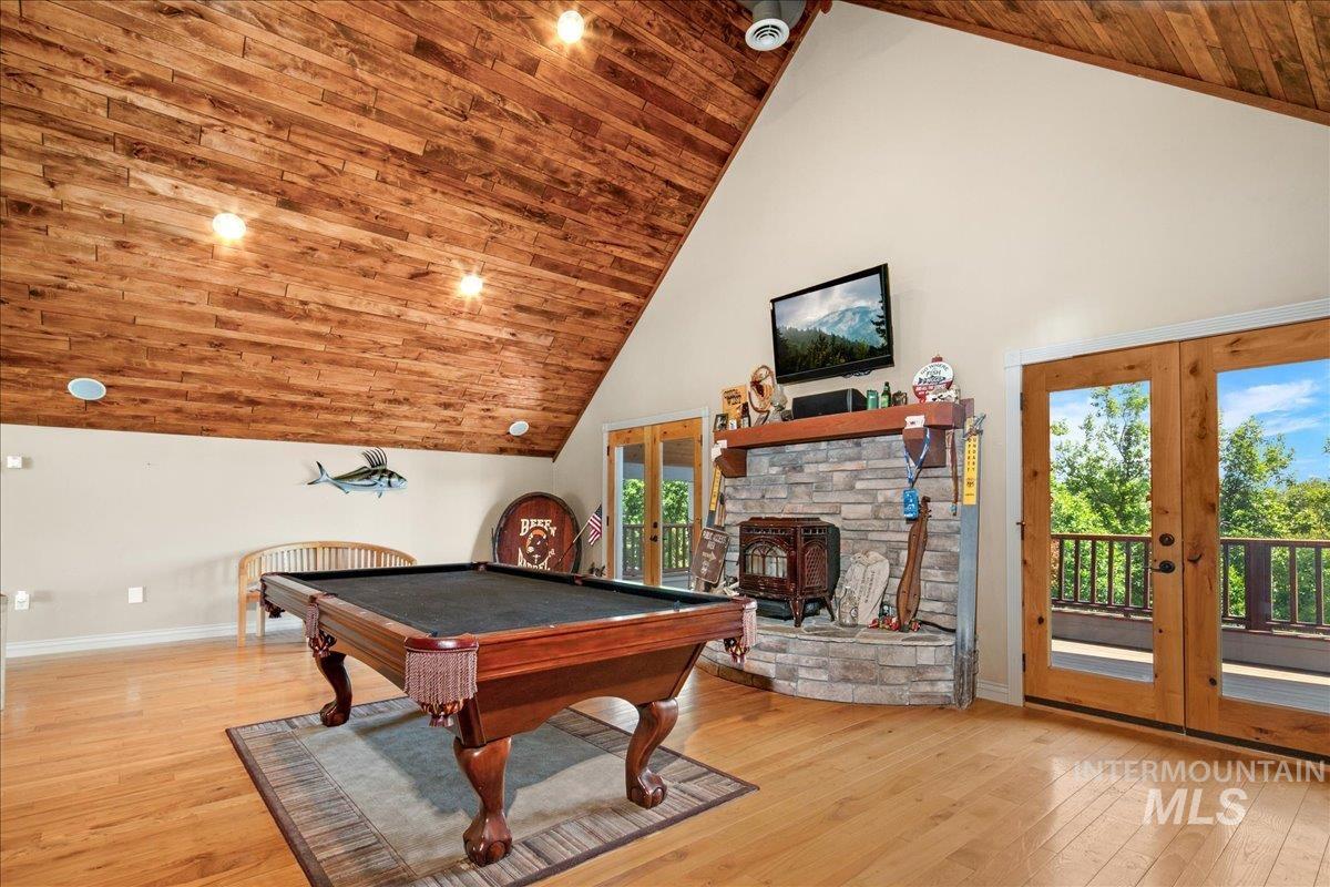 Recreation room featuring french doors, high vaulted ceiling, wood-type flooring, wooden ceiling, and billiards
