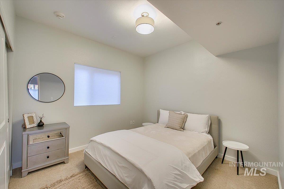 Bedroom featuring light carpet