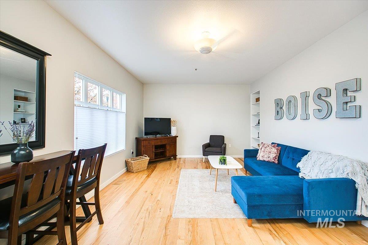 Living room with light wood-type flooring and built in shelves