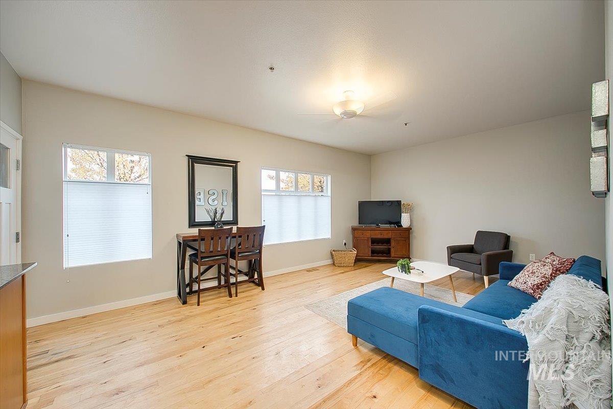 Living room featuring light wood-style floors, plenty of natural light, and ceiling fan