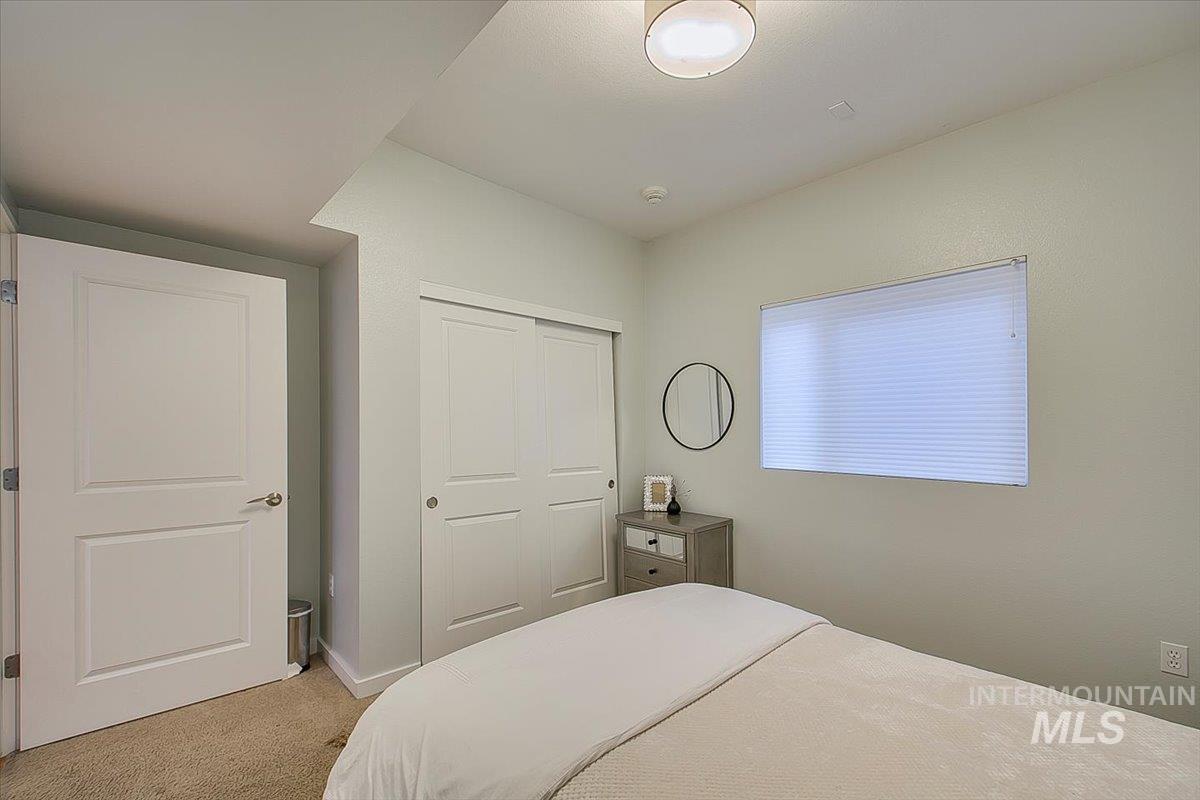 Bedroom with light carpet and a closet