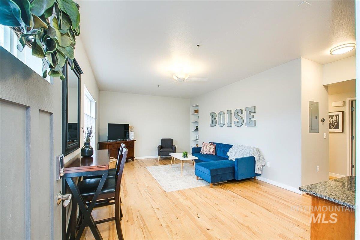 Living area with electric panel and light wood-style flooring