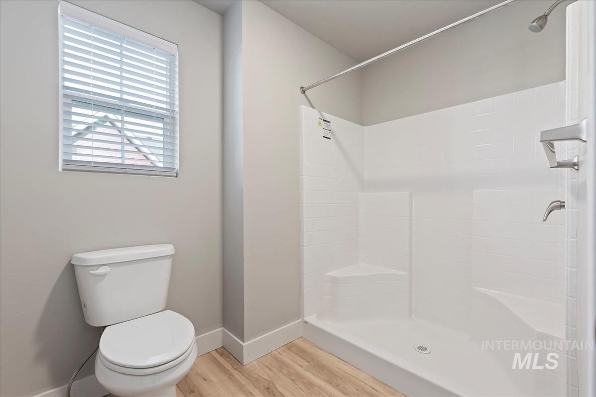 Bathroom with a stall shower and light wood-style floors