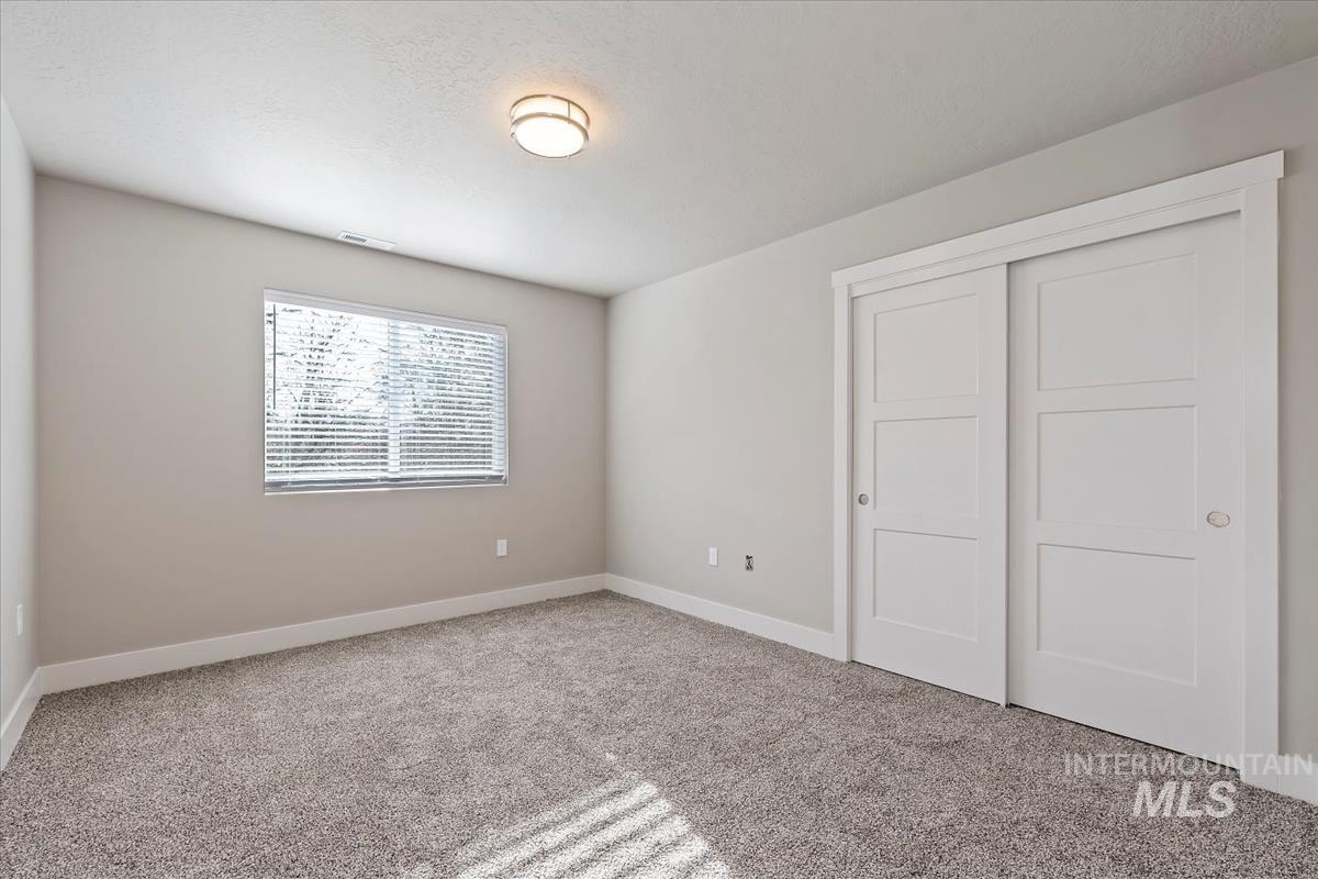 Unfurnished bedroom with carpet flooring and a closet