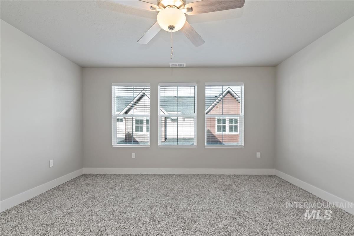 Spare room with carpet floors and a ceiling fan