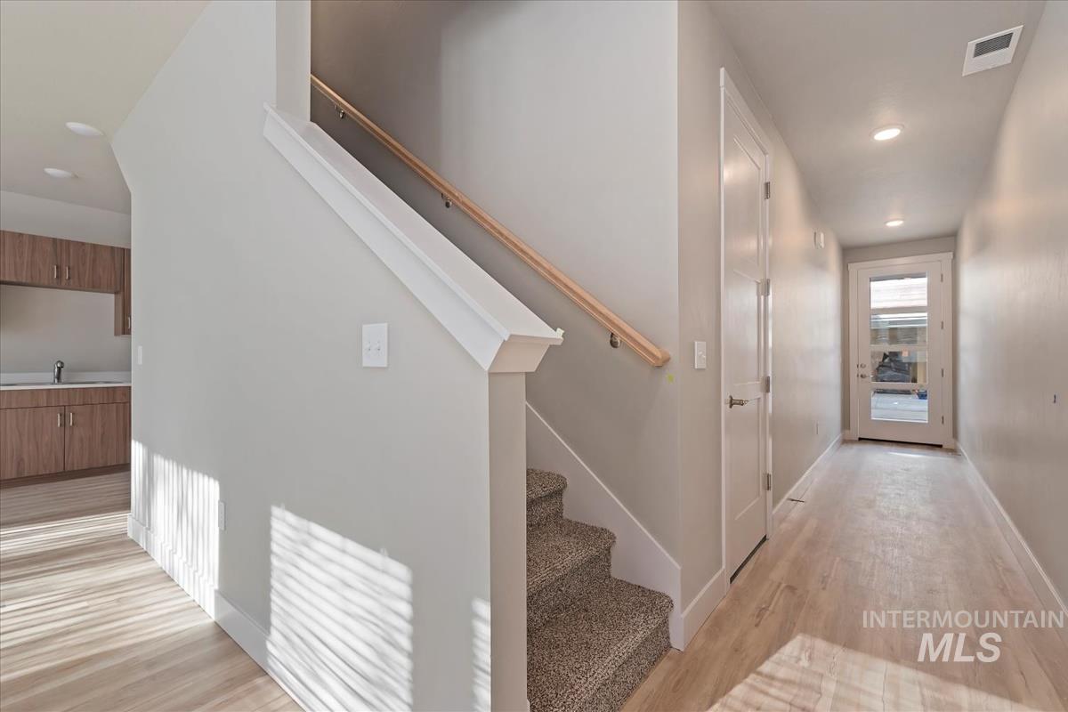Staircase with recessed lighting and wood finished floors